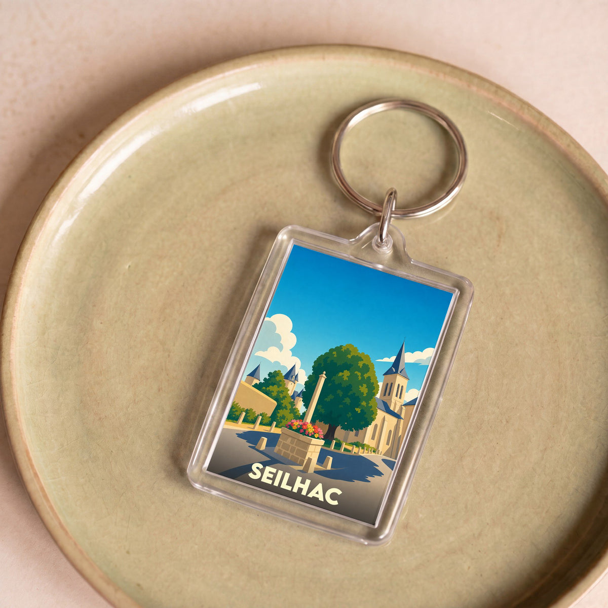 Porte-clés souvenir de la ville de Seilhac avec une illustration stylisée.