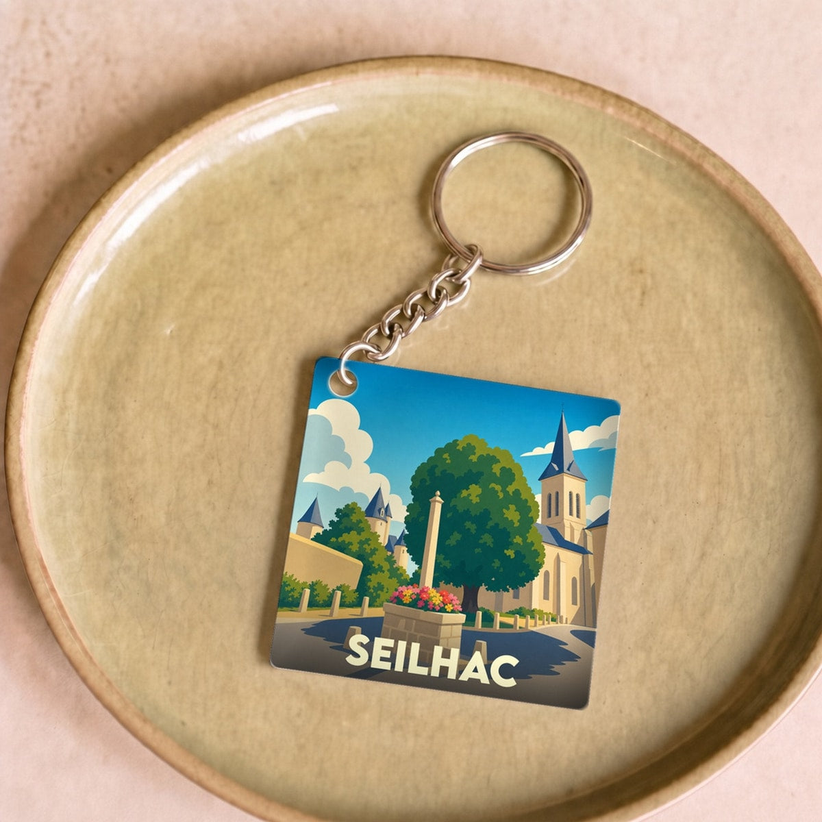 Porte-clés souvenir de la ville de Seilhac avec une illustration stylisée.
