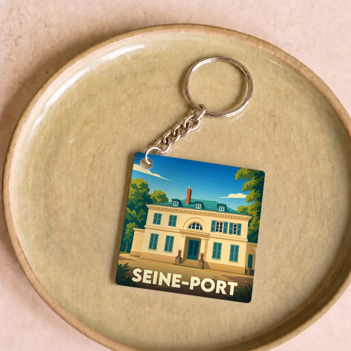 Porte-clés souvenir de la ville de Seine-Port avec une illustration stylisée d'une demeure historique.