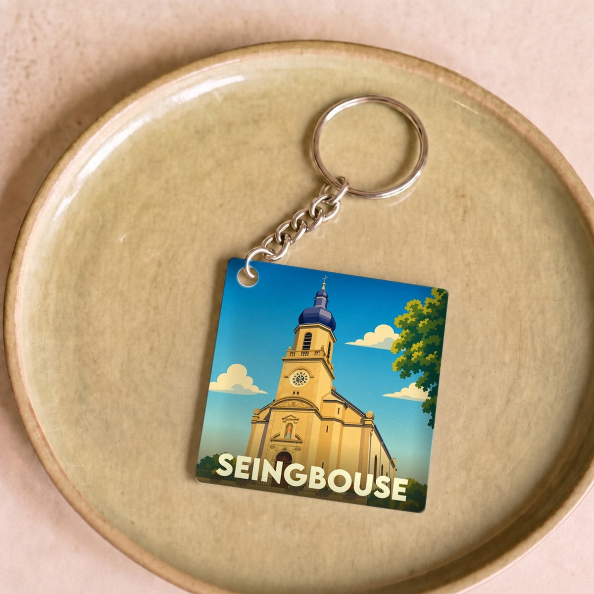 Porte-clés souvenir de la ville de Seingbouse avec une illustration stylisée de son église.