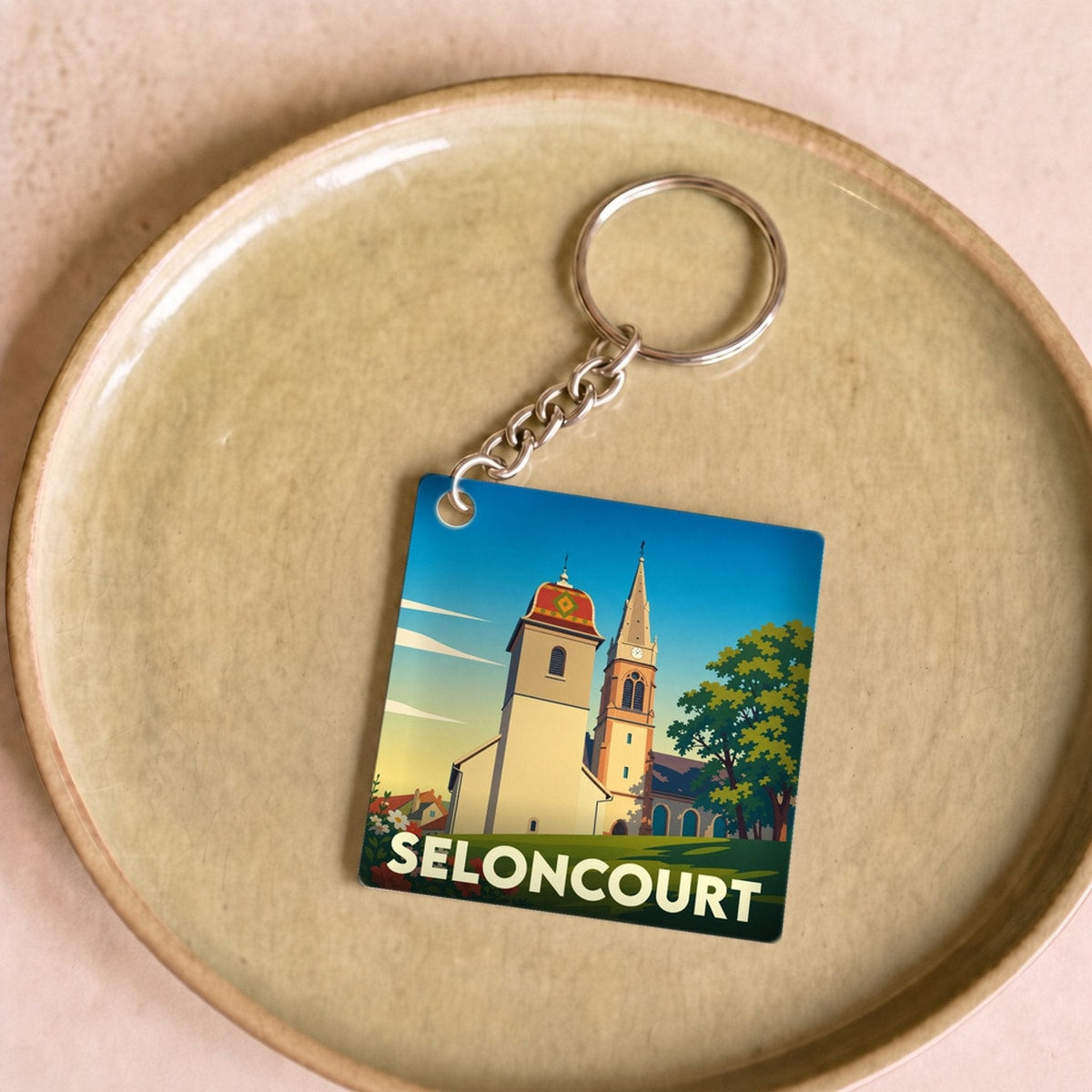 Porte-clés souvenir de la ville de Seloncourt avec une illustration stylisée.