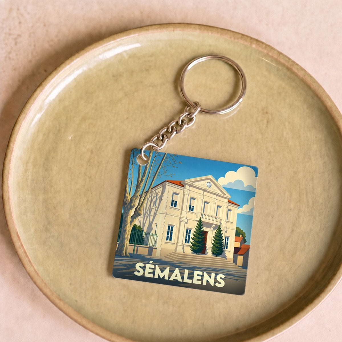 Porte-clés souvenir de la ville de Sémalens avec une illustration stylisée de sa mairie.