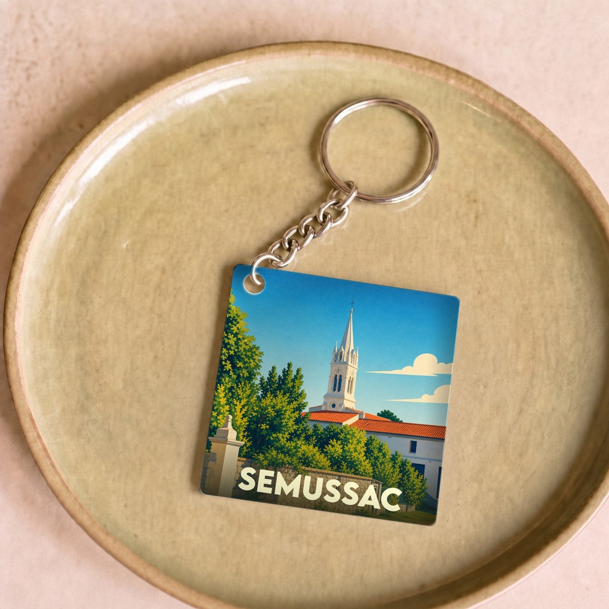 Porte-clés souvenir de la ville de Semussac avec une illustration stylisée de son église.