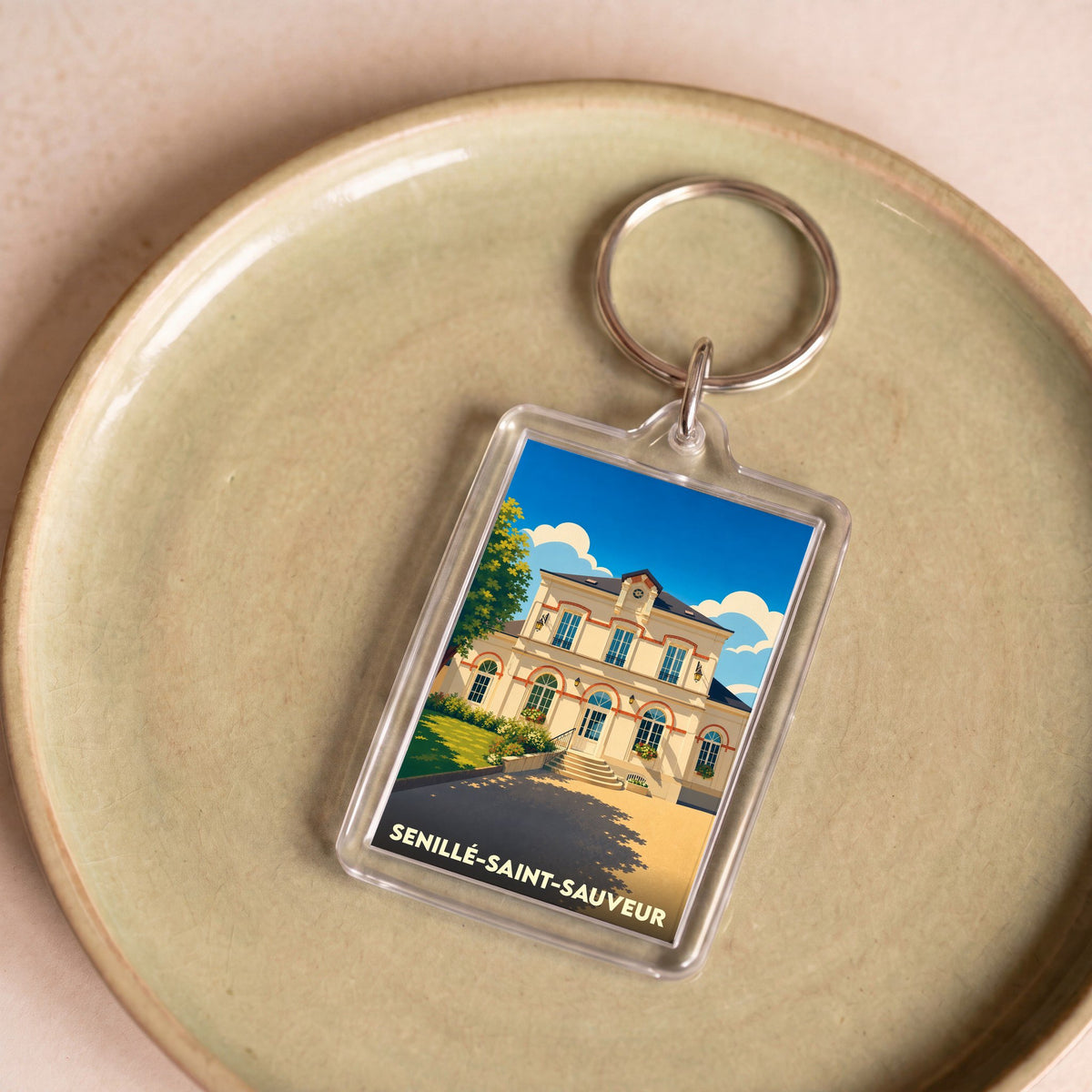 Porte-clés souvenir de la ville de Senillé-Saint-Sauveur avec une illustration stylisée.