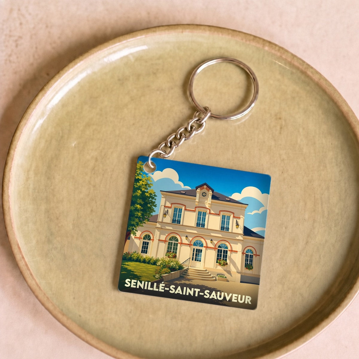 Porte-clés souvenir de la ville de Senillé-Saint-Sauveur avec une illustration stylisée.