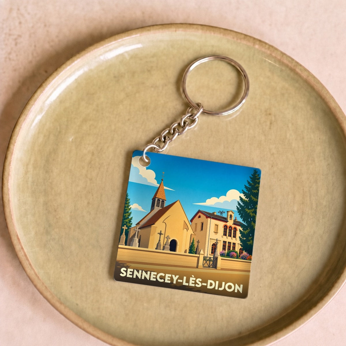 Porte-clés souvenir de la ville de Sennecey-lès-Dijon avec une illustration stylisée.