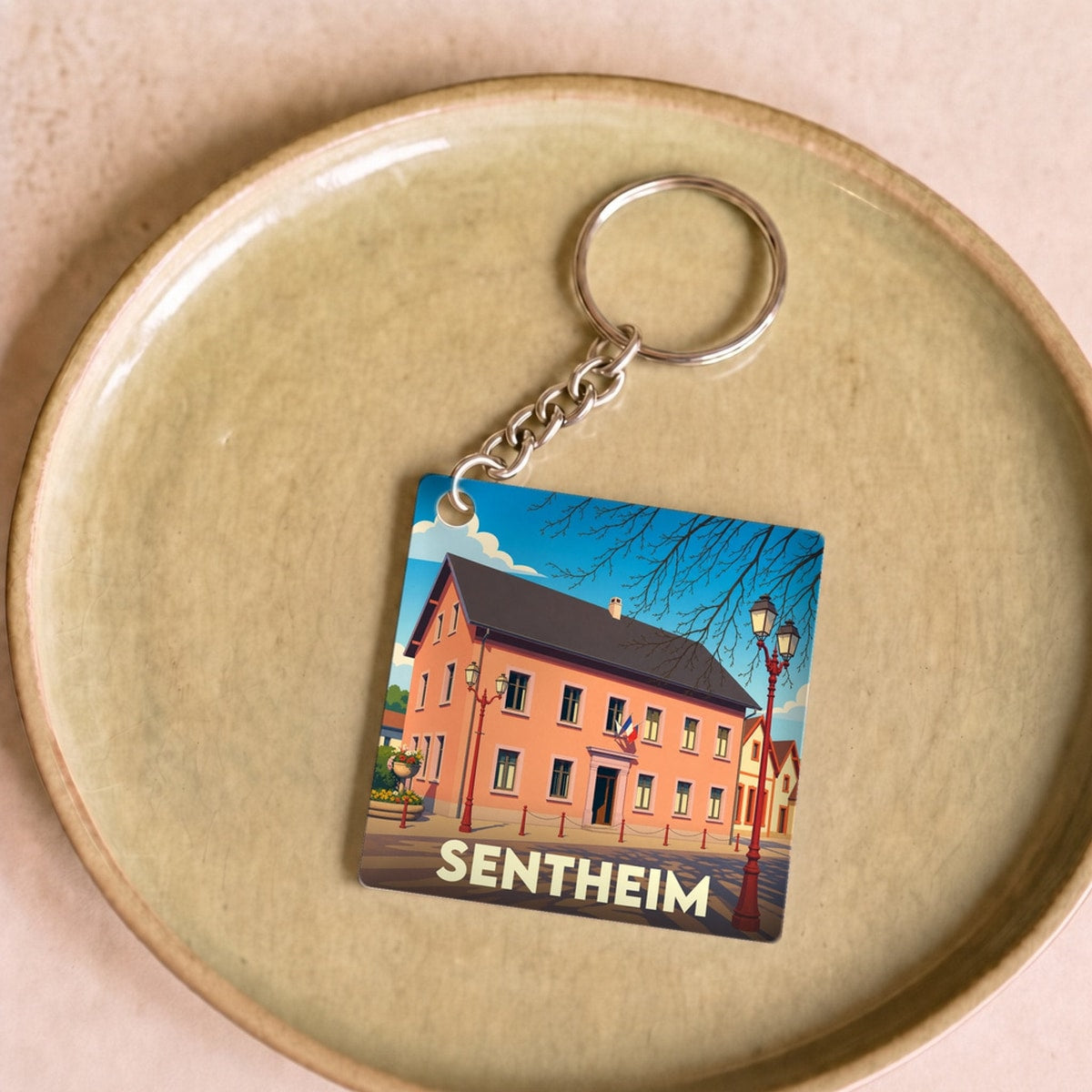 Porte-clés souvenir de la ville de Sentheim avec une illustration stylisée.