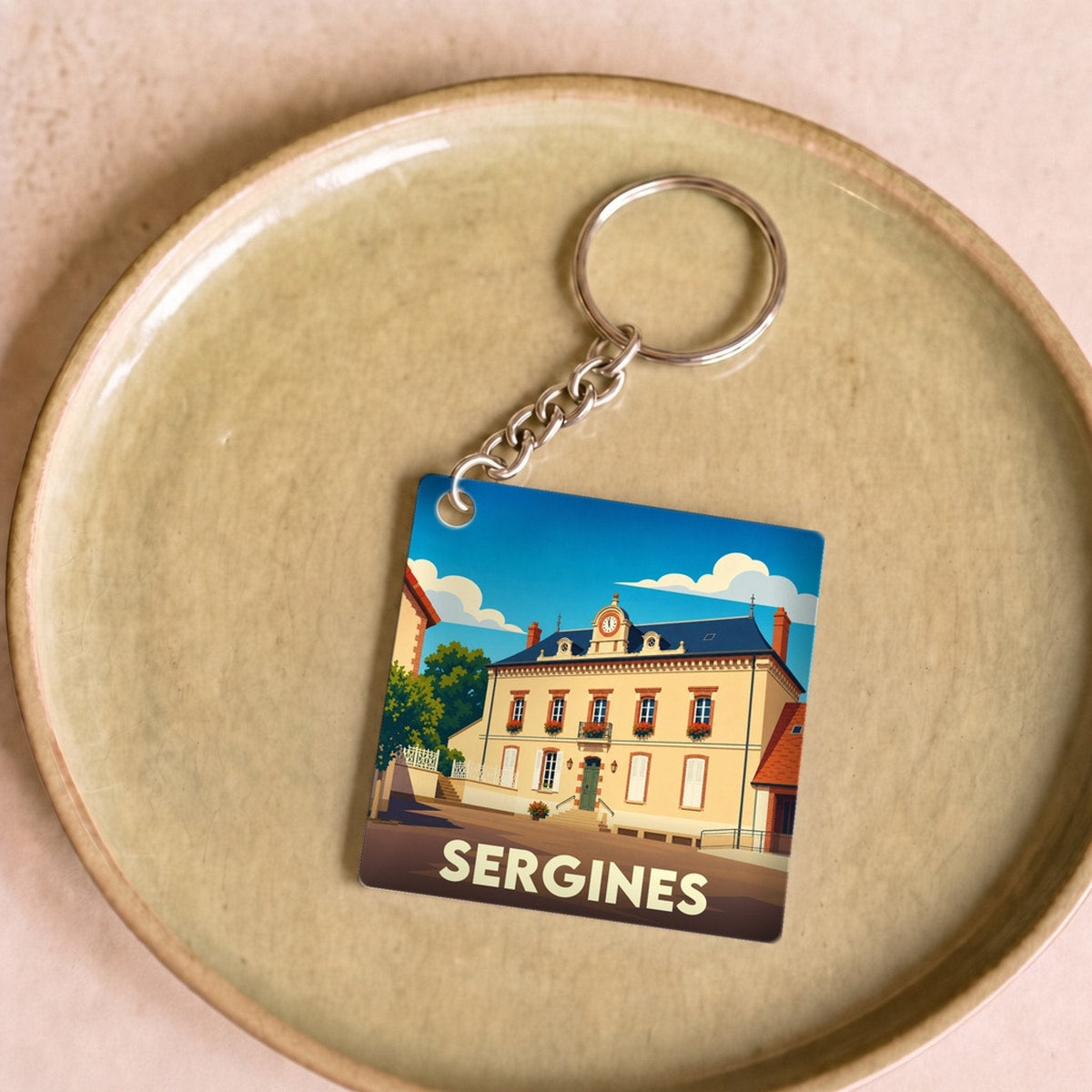Porte-clés souvenir de la ville de Sergines avec une illustration stylisée de la mairie.