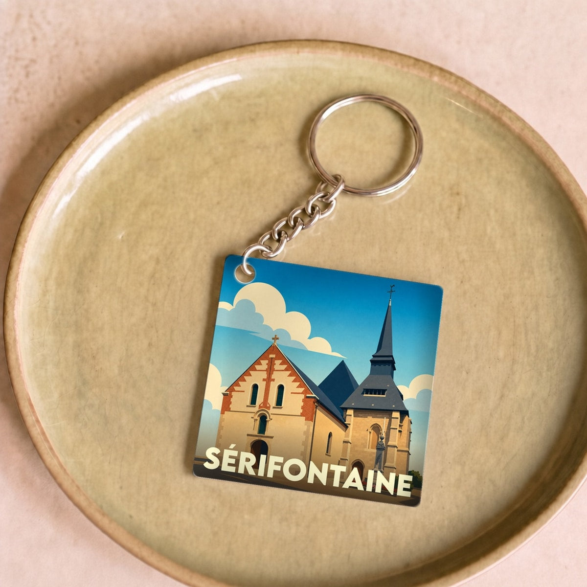 Porte-clés souvenir de la ville de Sérifontaine avec une illustration stylisée de son église.
