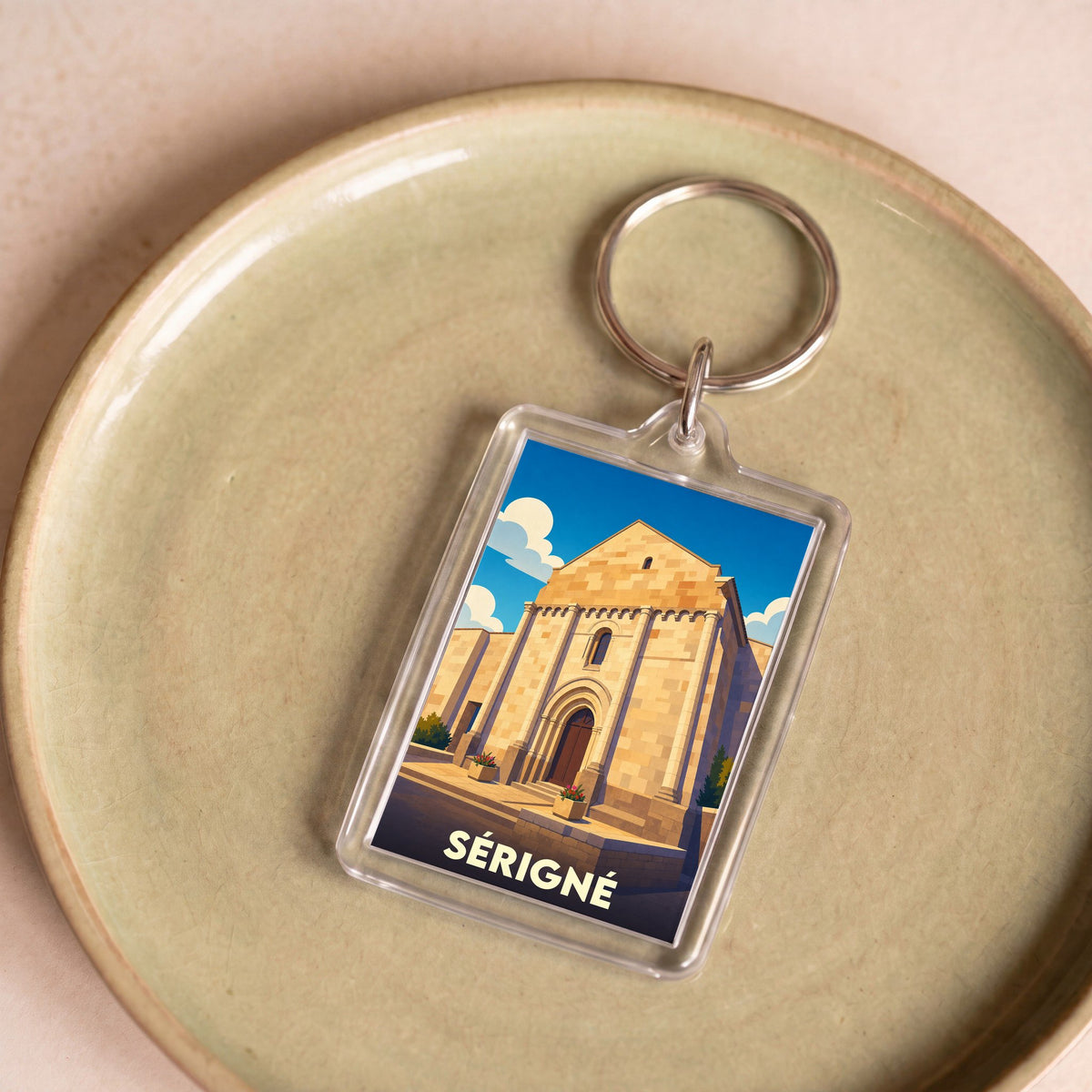 Porte-clés souvenir de la ville de Sérigné avec une illustration stylisée de son église.