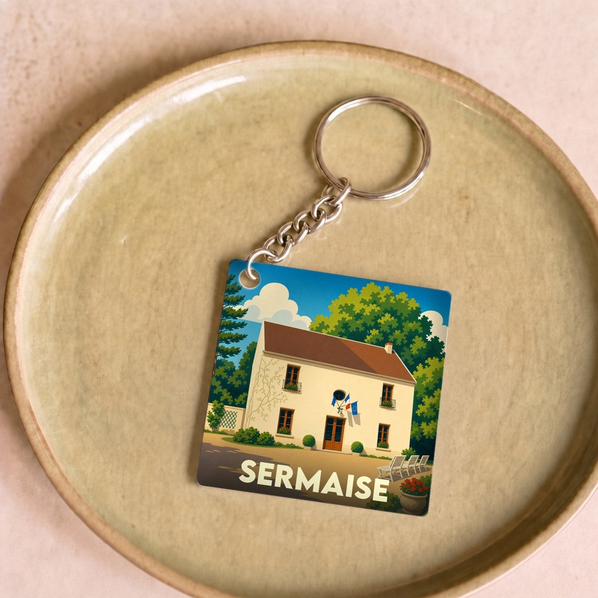 Porte-clés souvenir de la ville de Sermaise avec une illustration stylisée de sa mairie.
