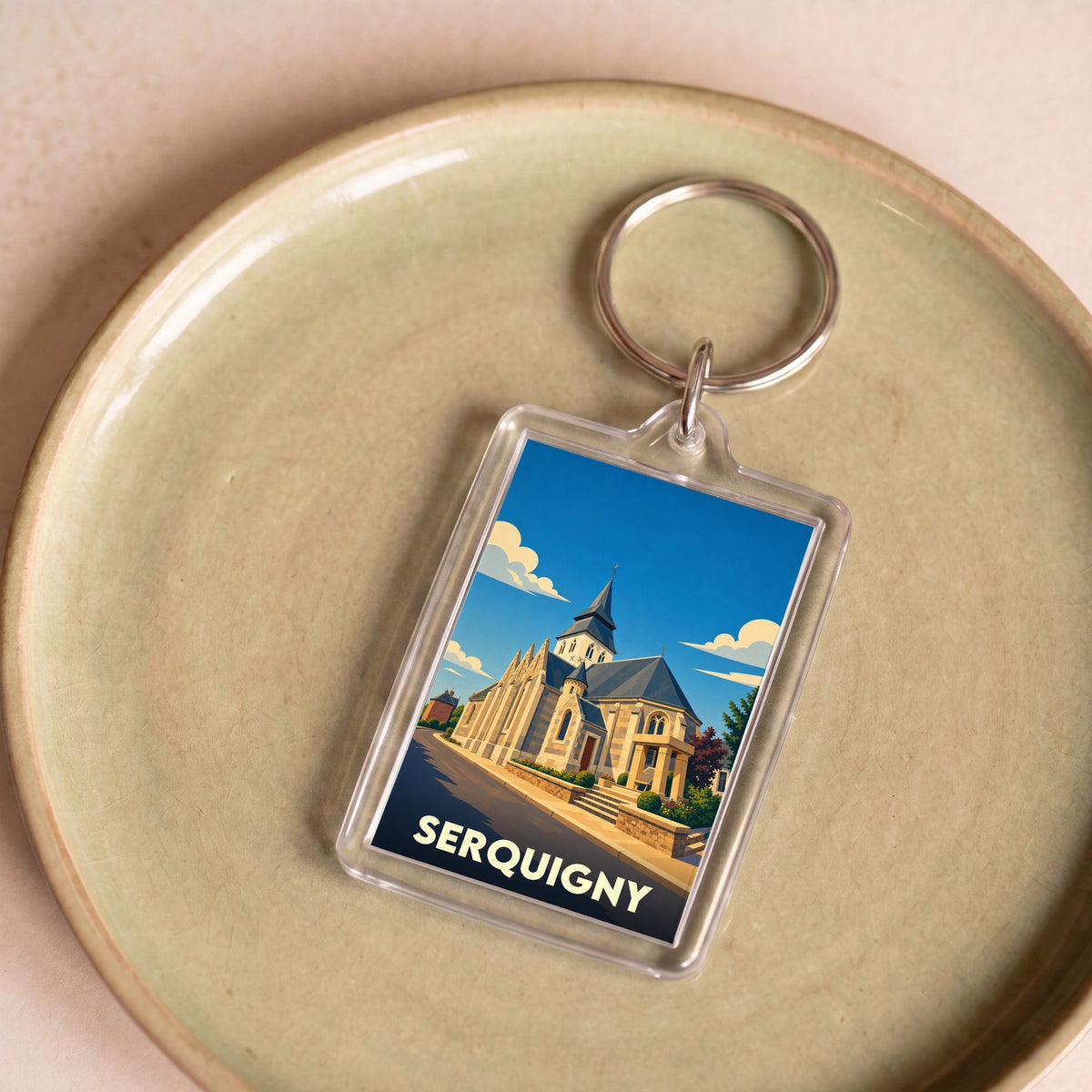 Porte-clés souvenir de la ville de Serquigny avec une illustration stylisée de son église.