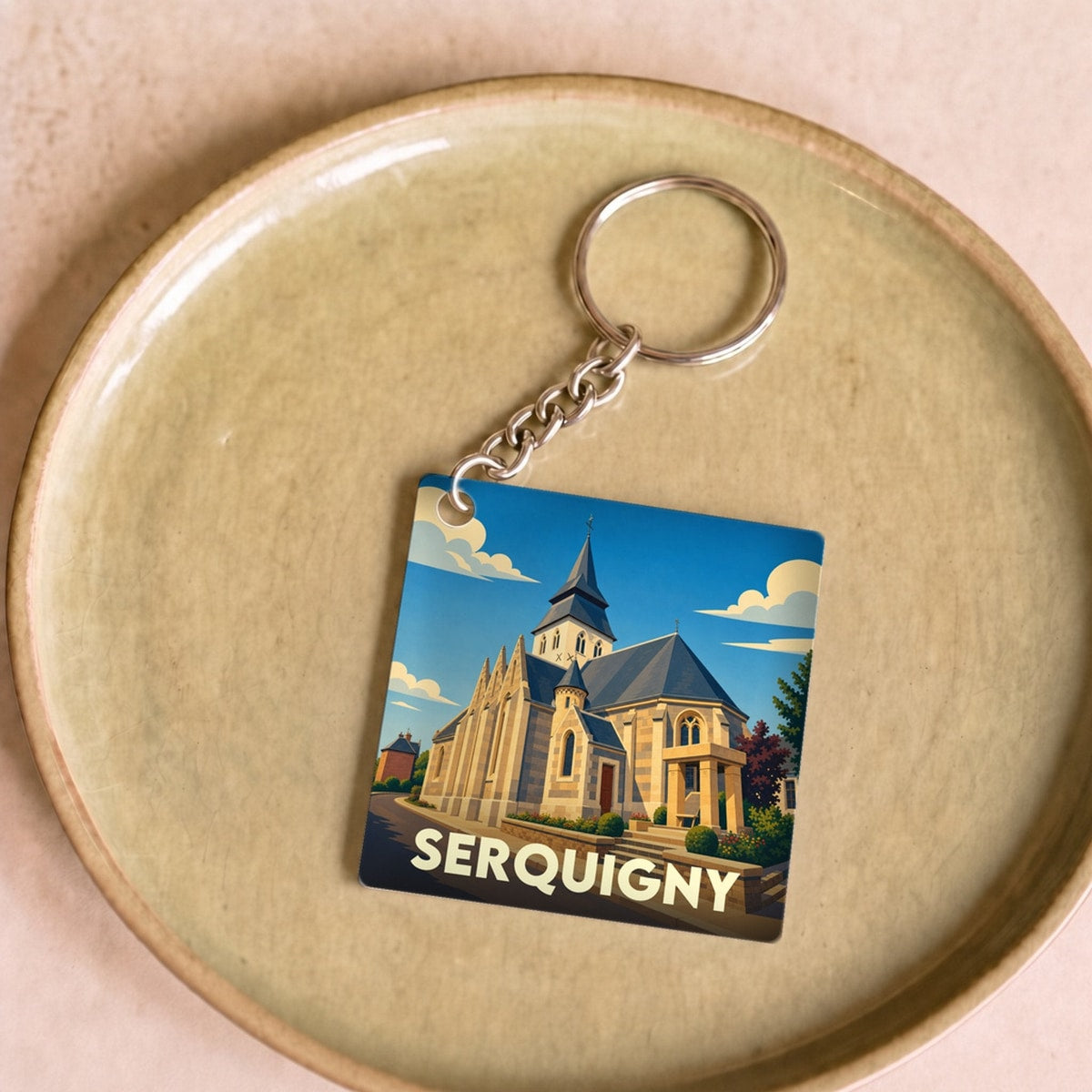 Porte-clés souvenir de la ville de Serquigny avec une illustration stylisée de son église.