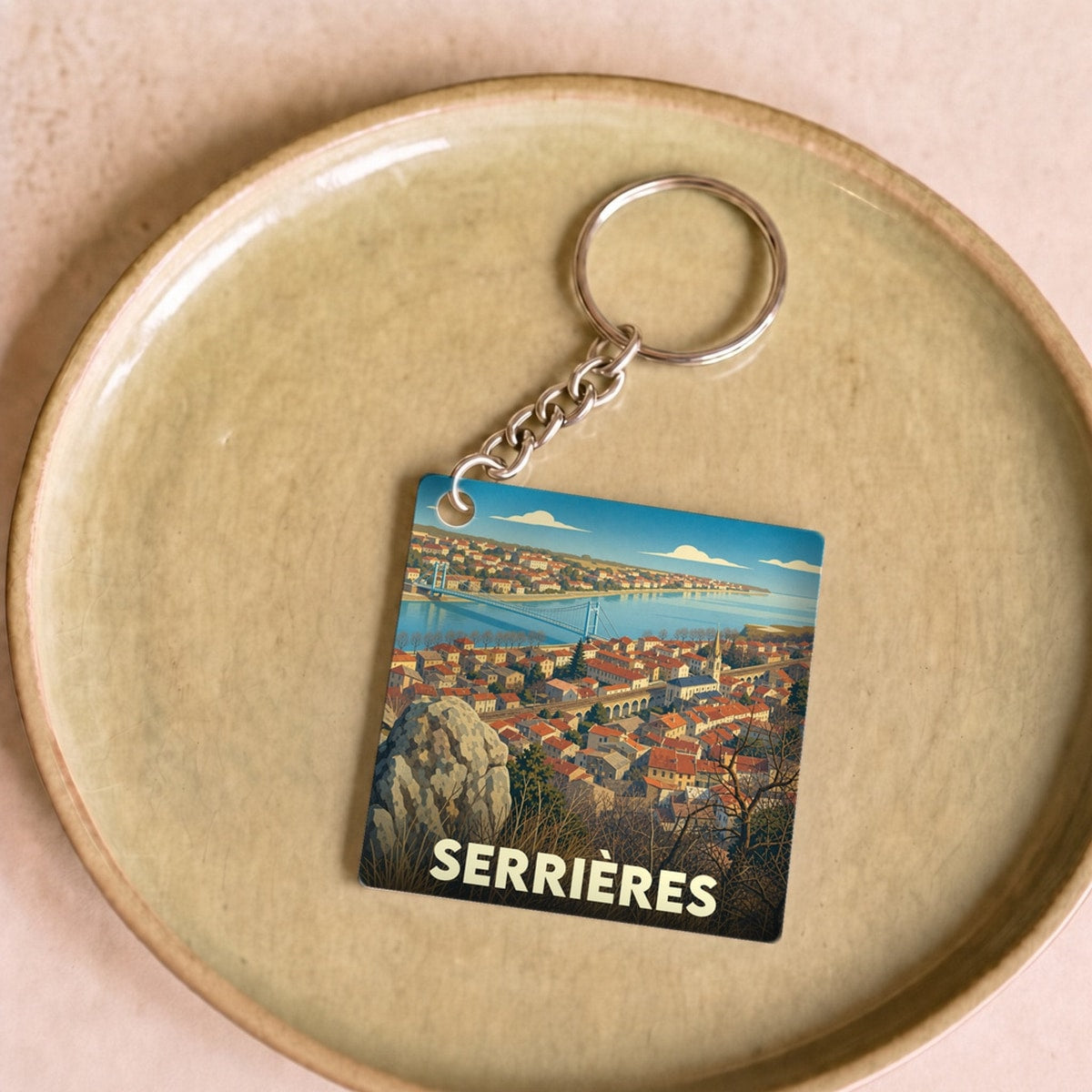 Porte-clés souvenir de la ville de Serrières avec une illustration stylisée.