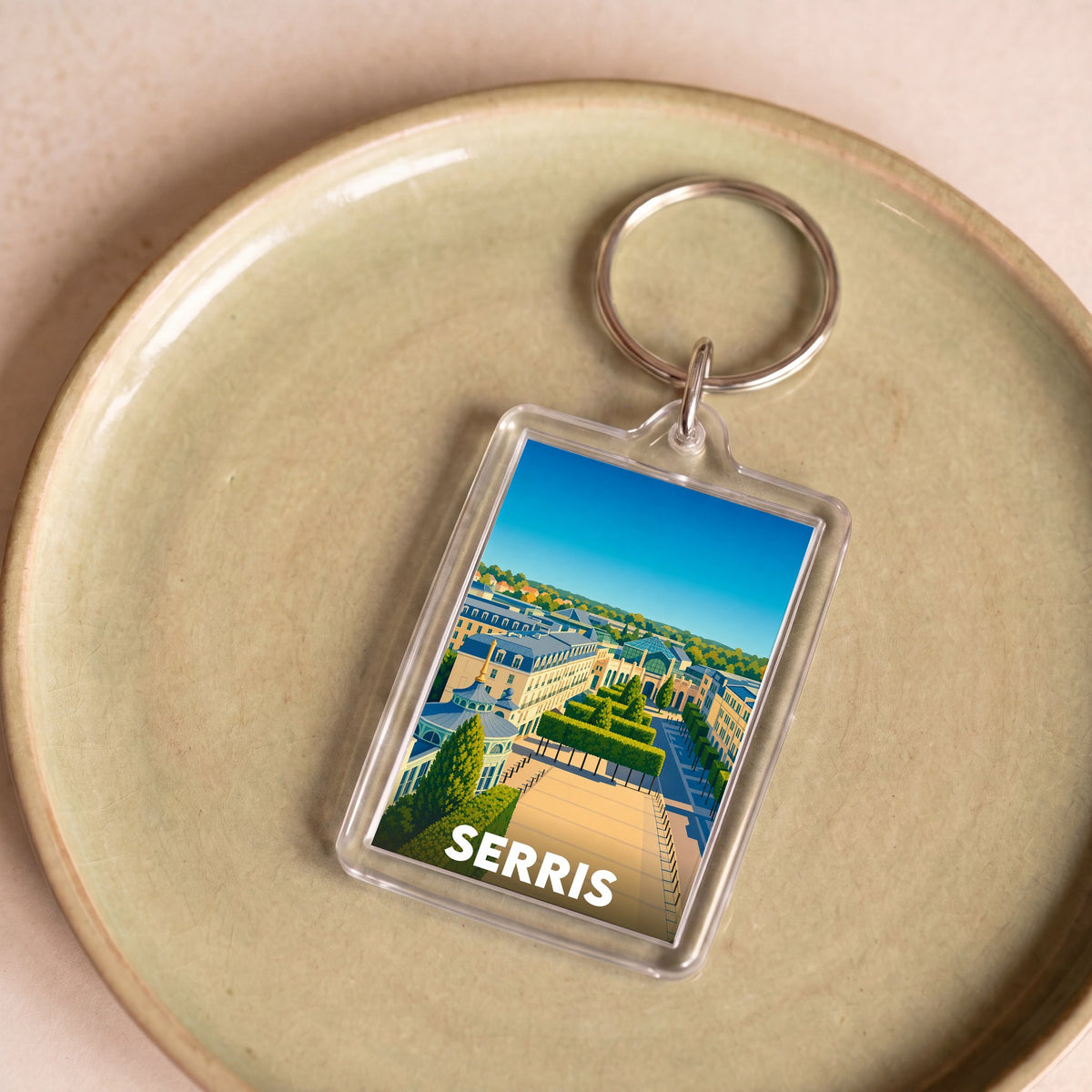 Porte-clés souvenir de la ville de Serris avec une illustration paysagère colorée.