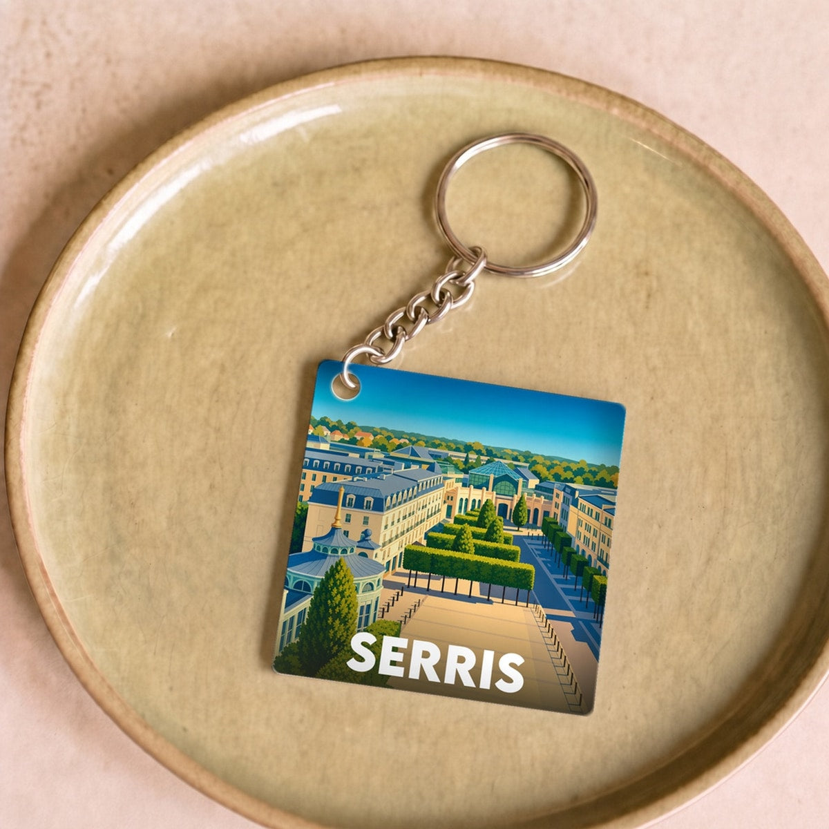 Porte-clés souvenir de la ville de Serris avec une illustration paysagère colorée.