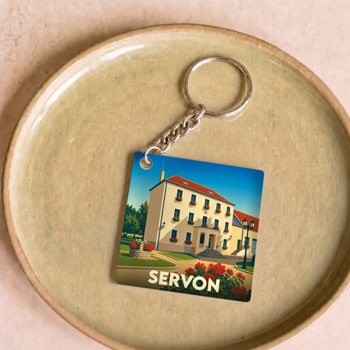 Porte-clés souvenir de la ville de Servon avec une illustration stylisée de sa mairie.