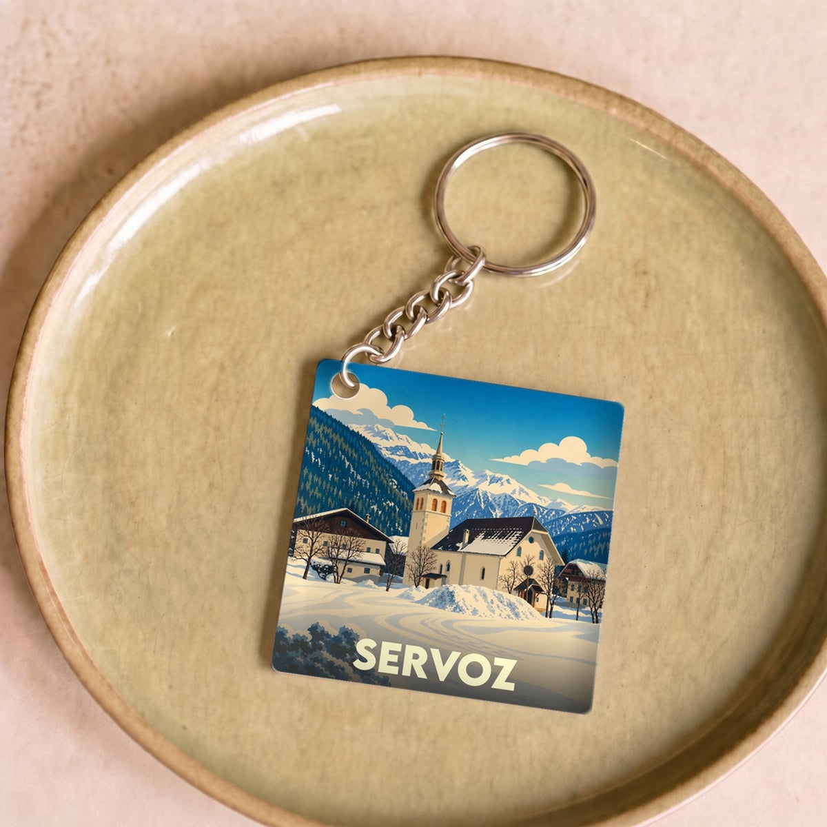 Porte-clés souvenir de la ville de Servoz avec une illustration hivernale stylisée.