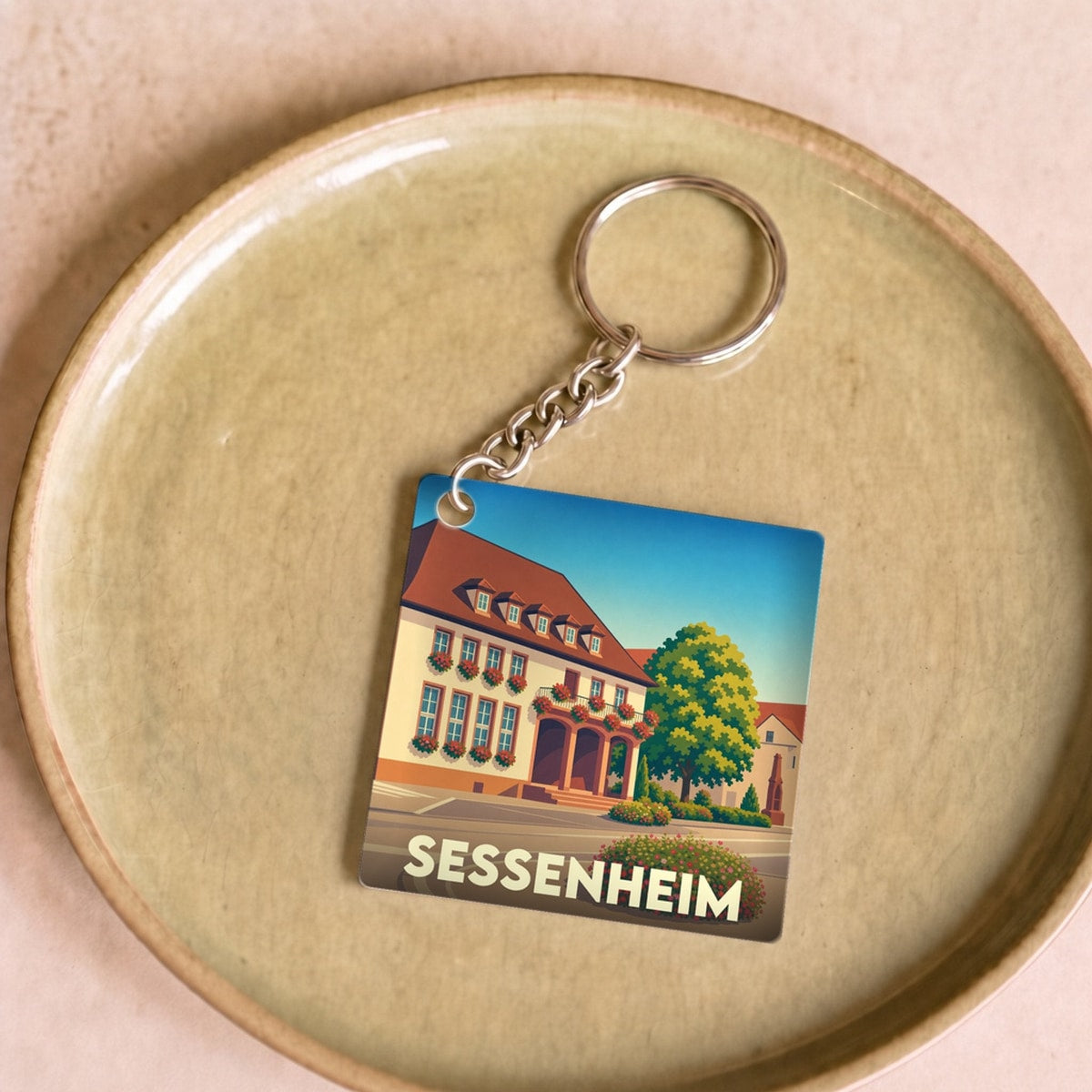 Porte-clés souvenir de la ville de Sessenheim avec une illustration stylisée.