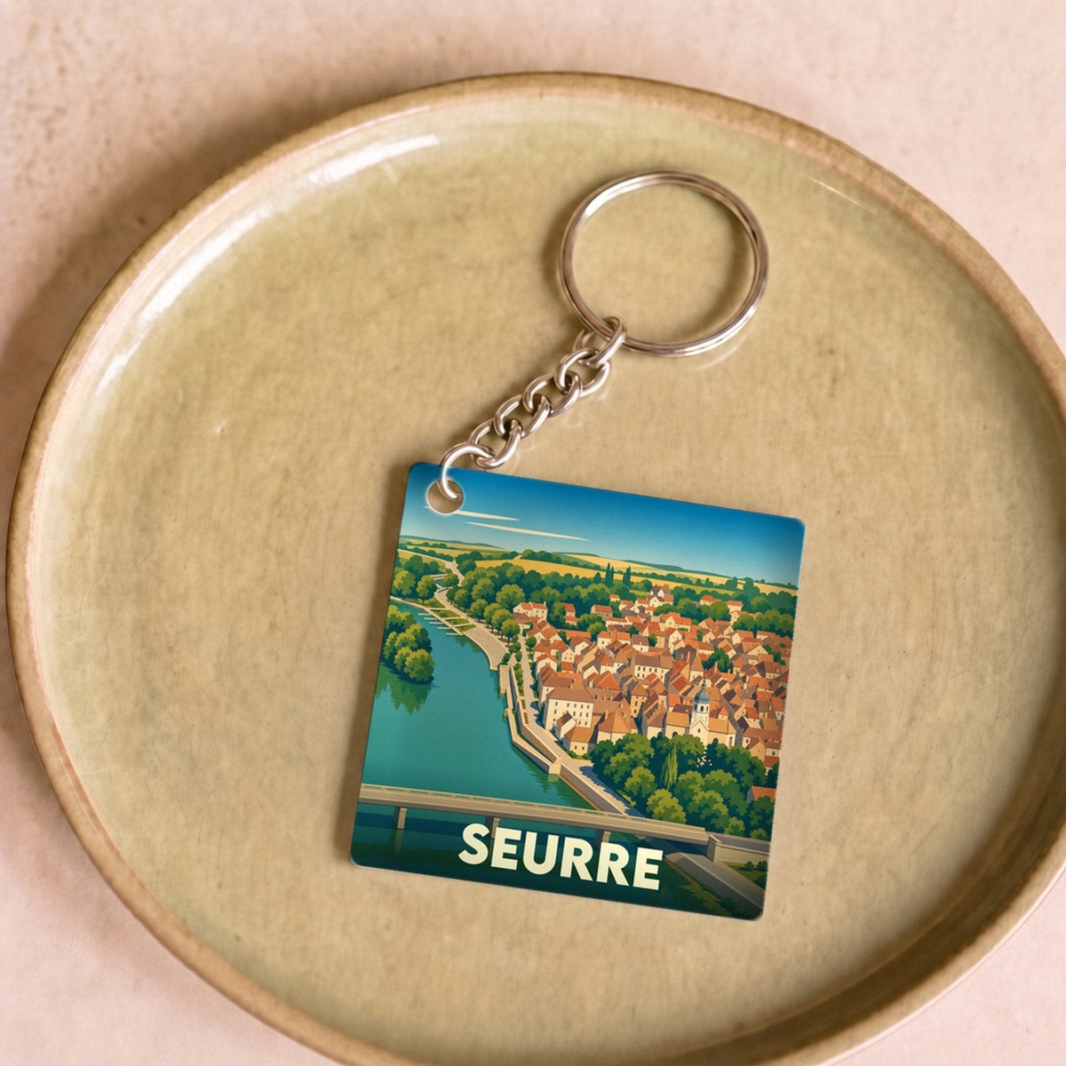 Porte-clés souvenir de la ville de Seurre avec une illustration stylisée.
