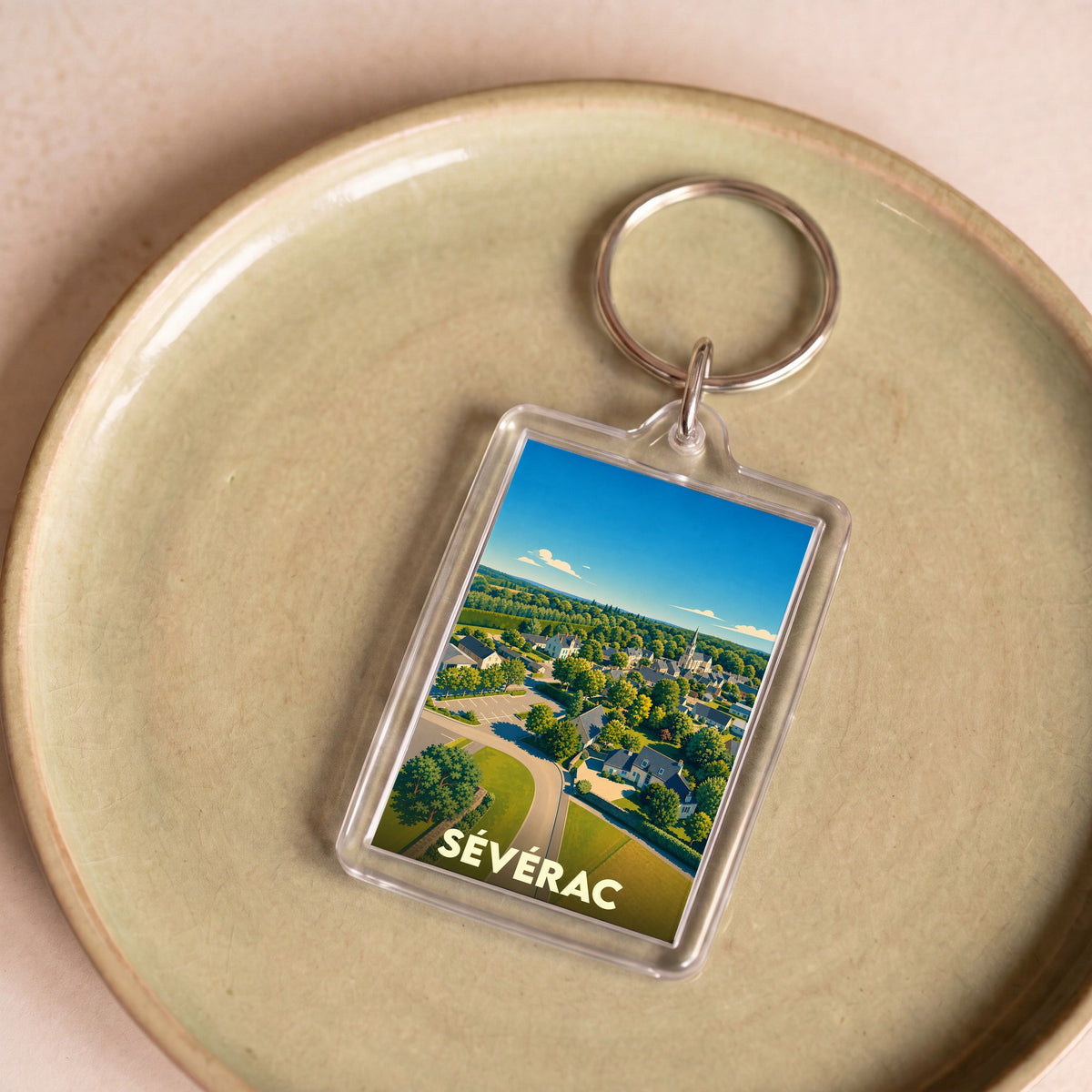 Porte-clés souvenir de la ville de Sévérac avec une illustration aérienne colorée.