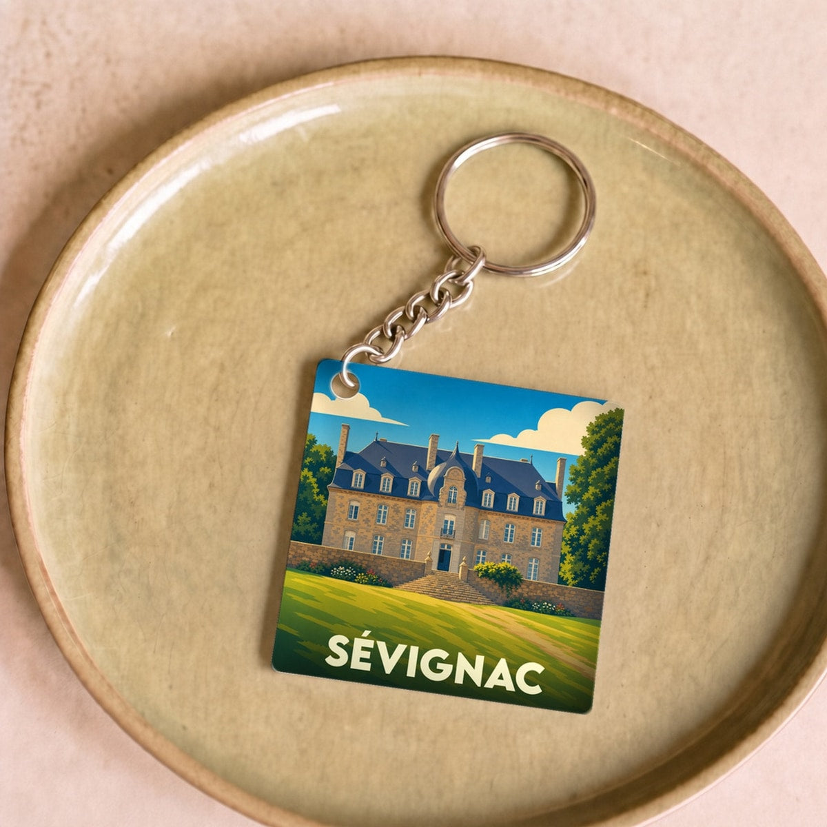 Porte-clés souvenir de la ville de Sévignac avec une illustration stylisée.
