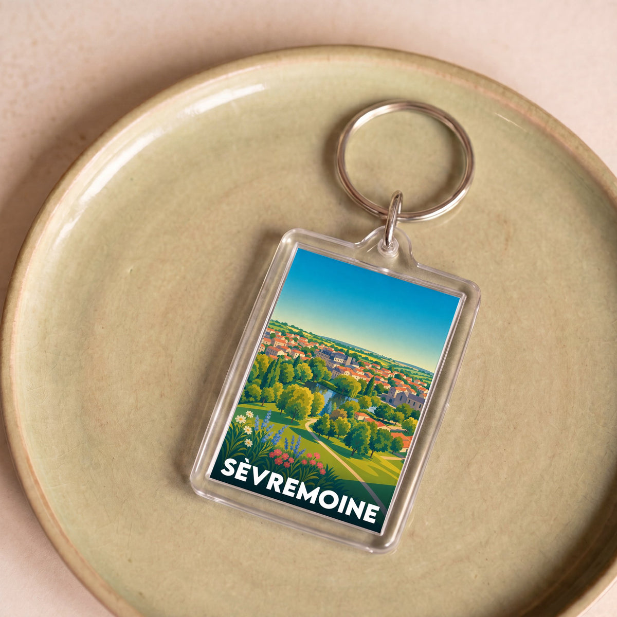 Porte-clés souvenir de la ville de Sèvremoine avec une illustration stylisée de son paysage.