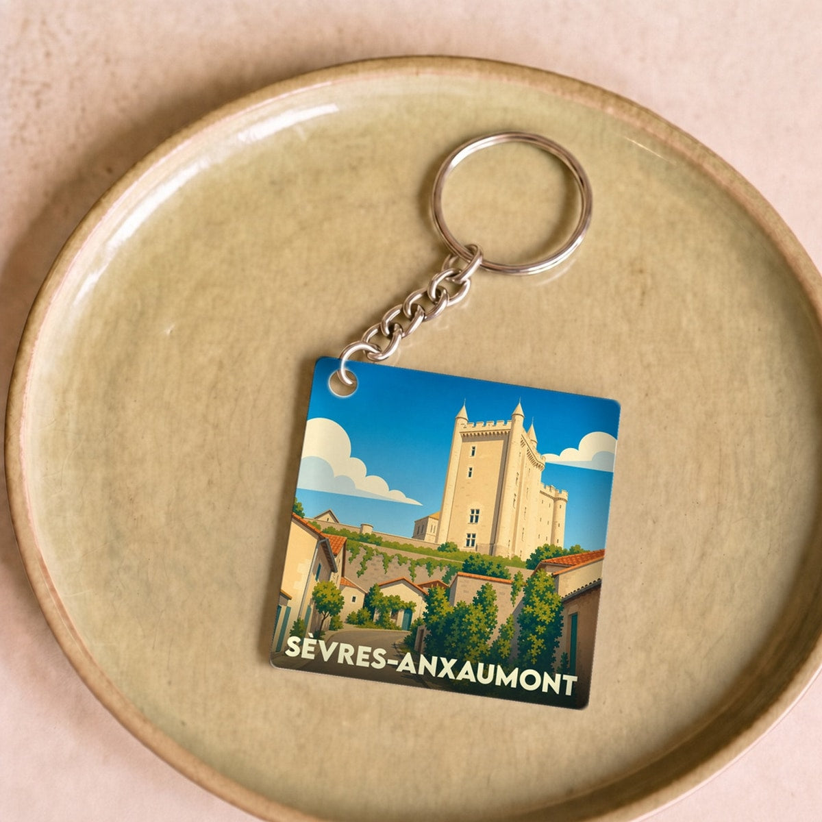 Porte-clés souvenir de la ville de Sèvres-Anxaumont avec une illustration stylisée d'un château.
