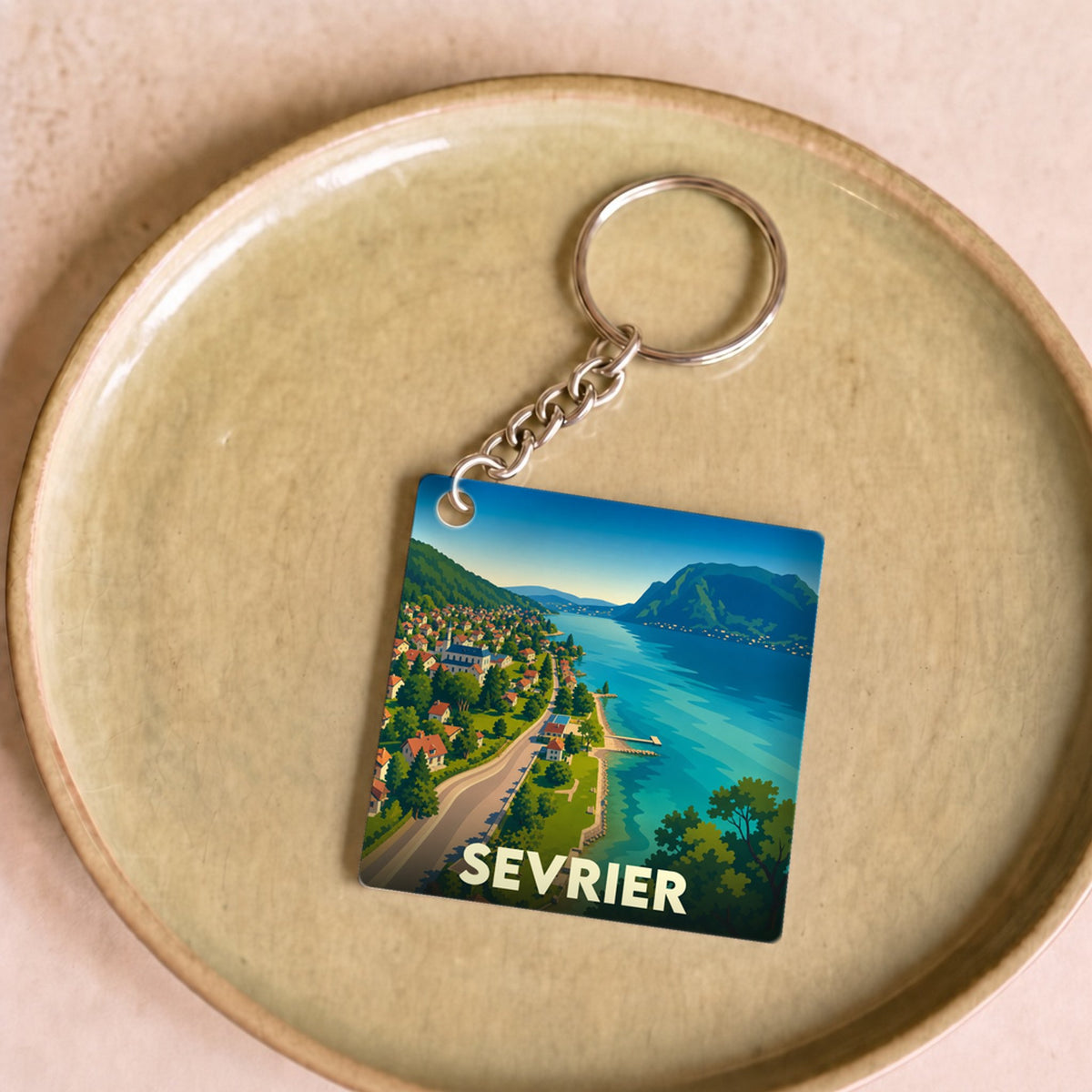 Porte-clés souvenir de la ville de Sevrier avec une illustration stylisée des bords du lac d'Annecy.