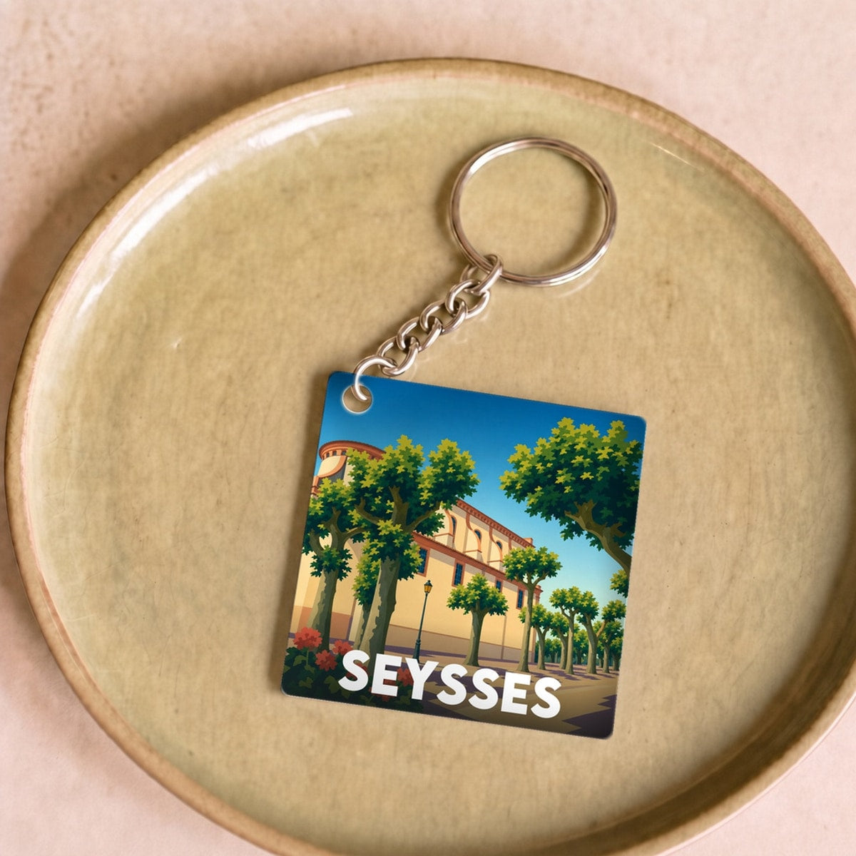 Porte-clés souvenir de la ville de Seysses avec une illustration stylisée.