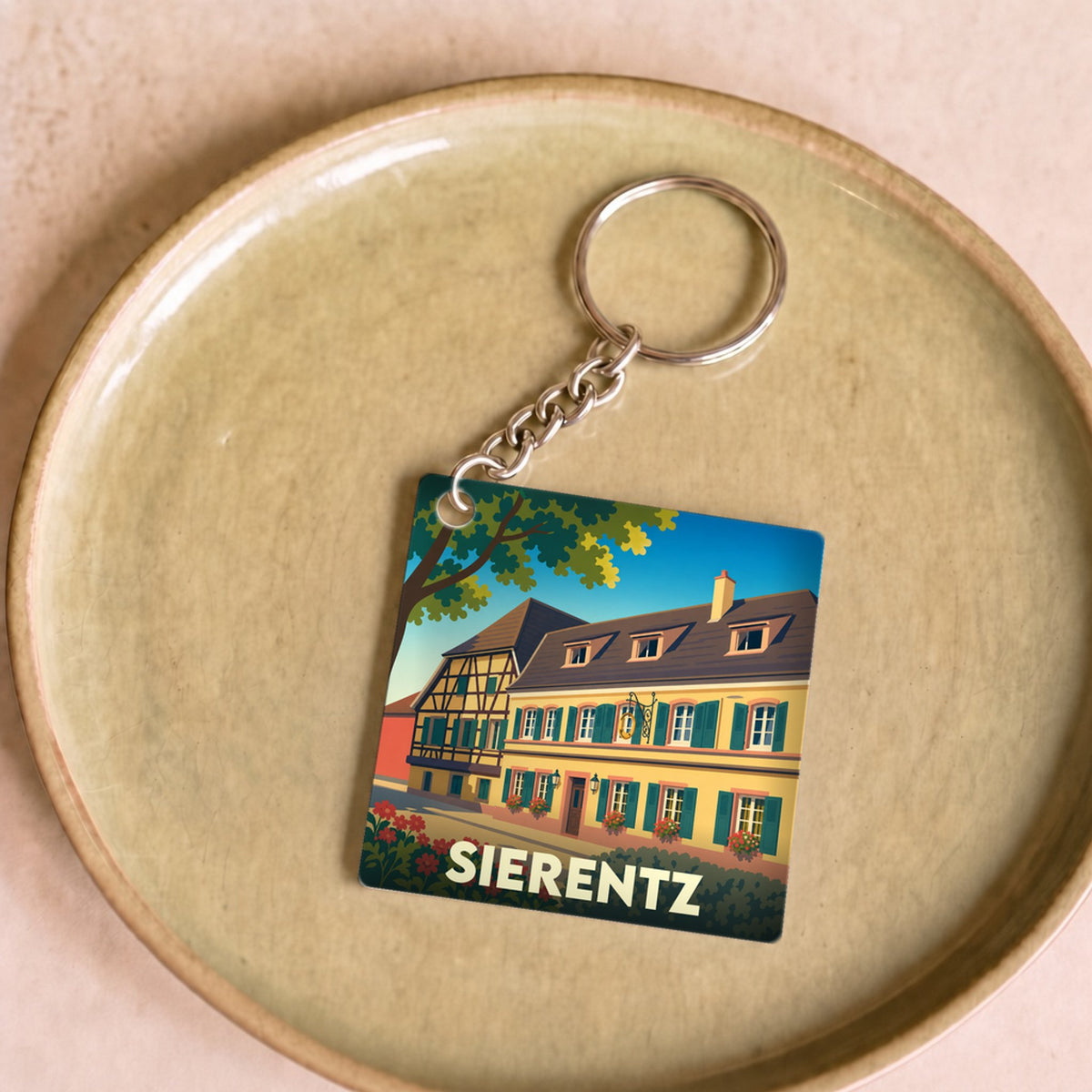 Porte-clés souvenir de la ville de Sierentz avec une illustration stylisée d'une maison traditionnelle à colombages.