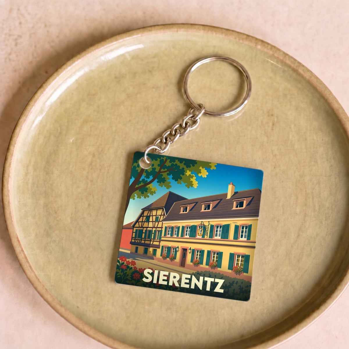 Porte-clés souvenir de la ville de Sierentz avec une illustration stylisée d'une maison traditionnelle à colombages.