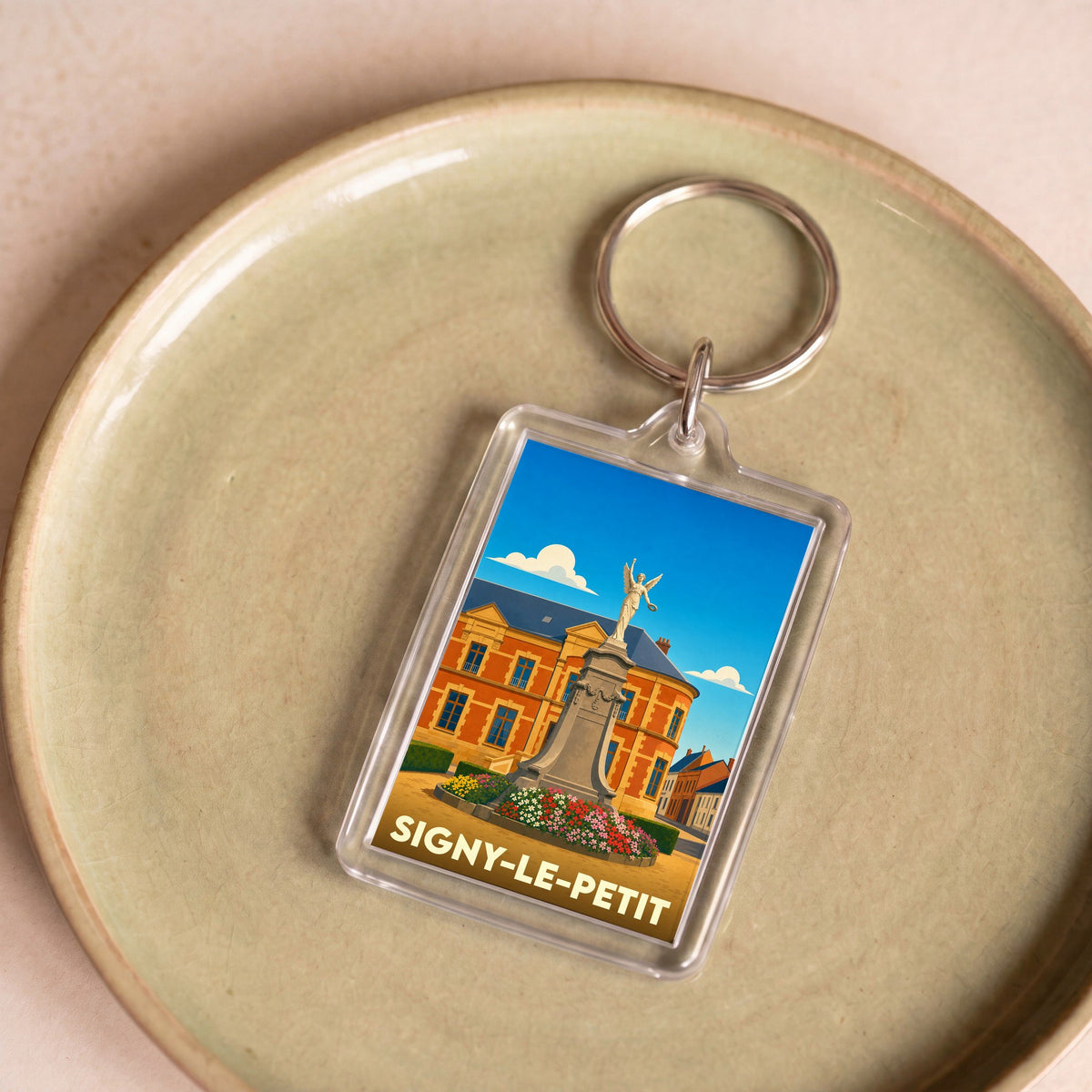 Porte-clés souvenir de la ville de Signy-le-Petit avec une illustration stylisée.