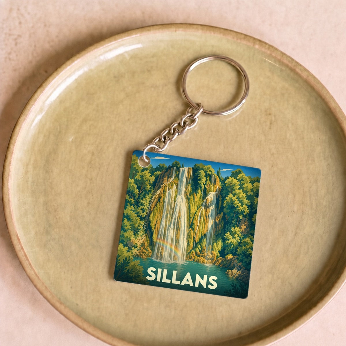 Porte-clés souvenir de la ville de Sillans avec une illustration stylisée de sa cascade.