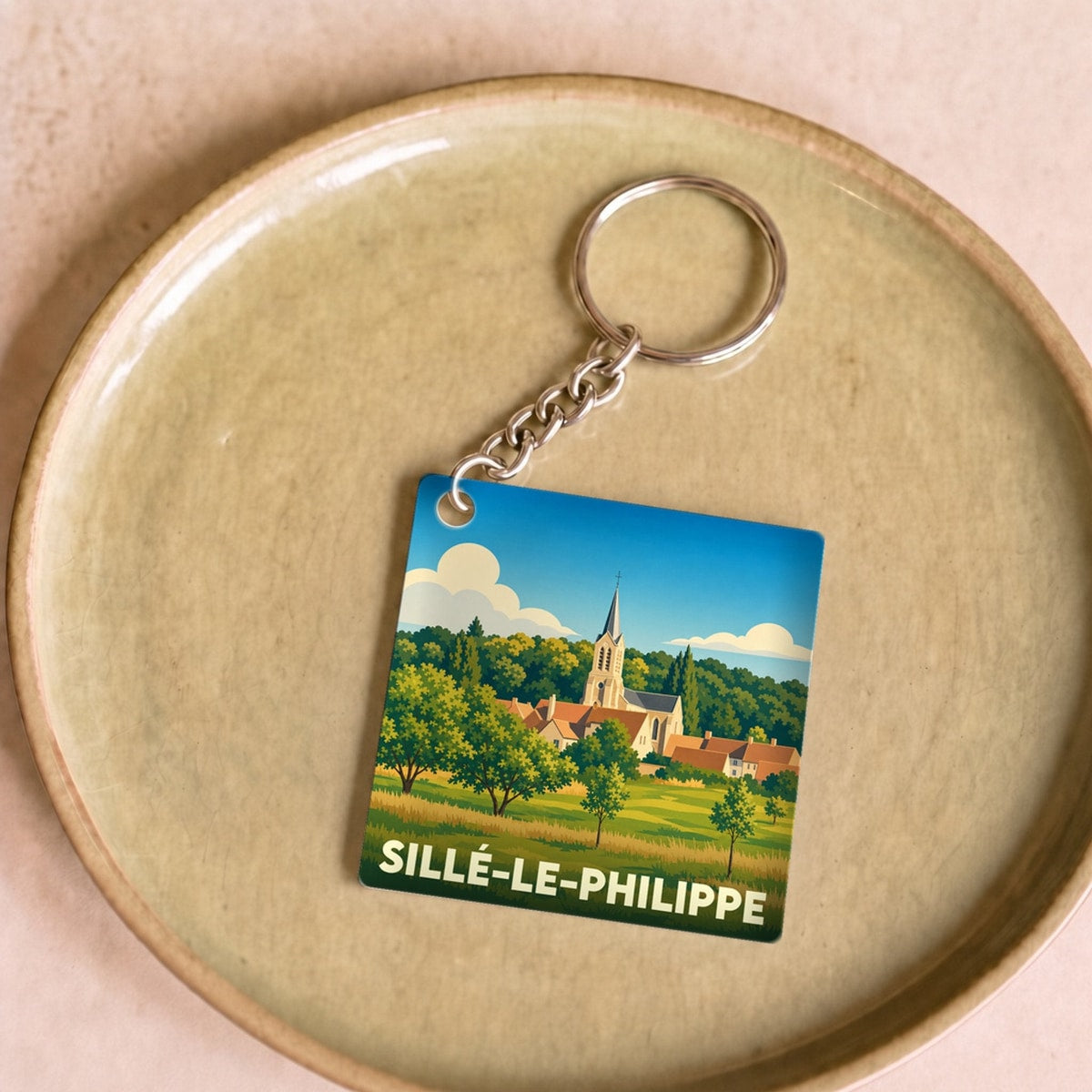 Porte-clés souvenir de Sillé-le-Philippe avec une illustration stylisée du village.