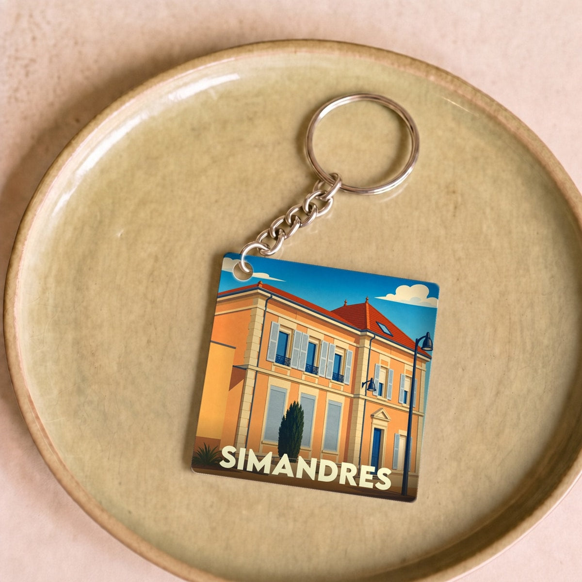 Porte-clés souvenir de la ville de Simandres avec une illustration stylisée.