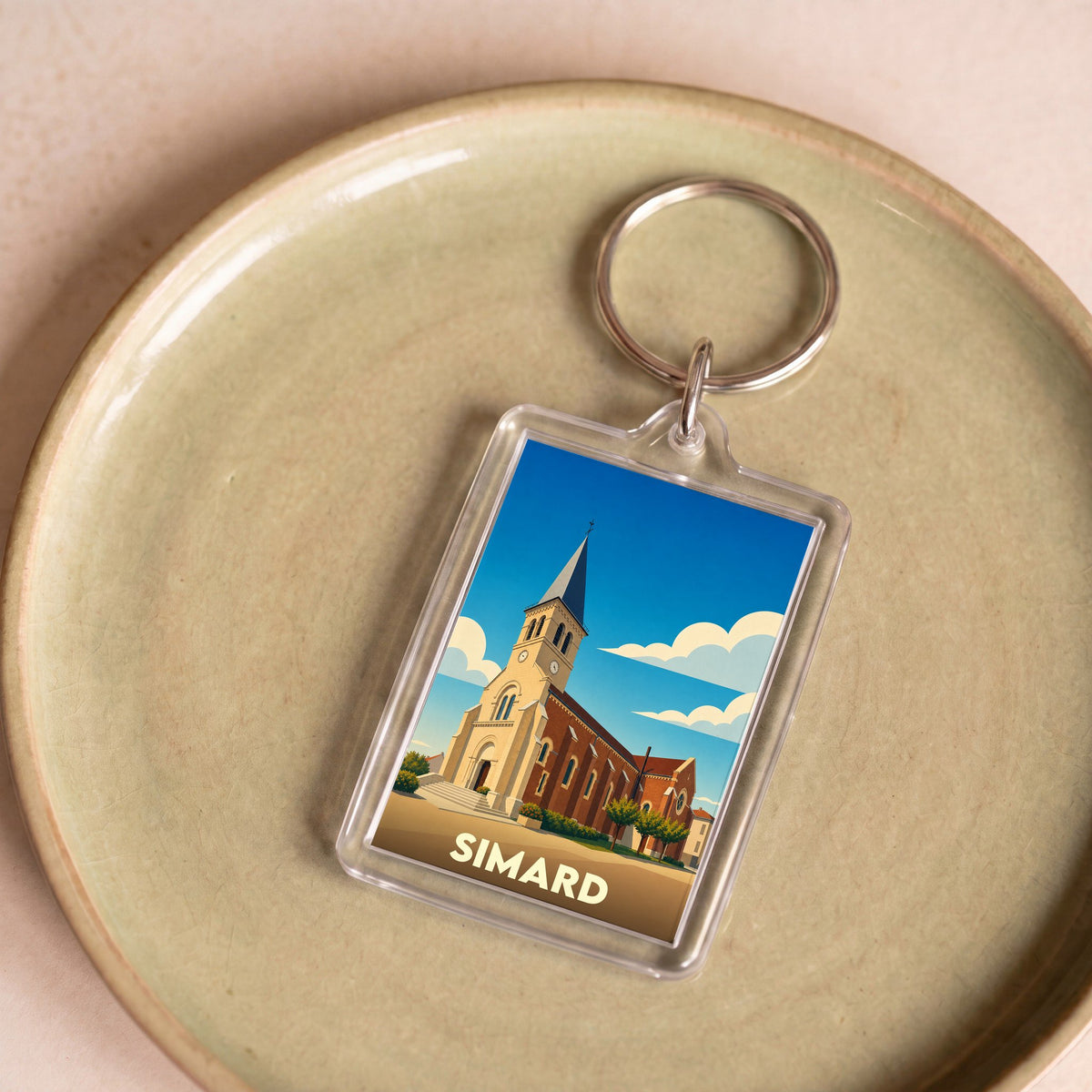 Porte-clés souvenir de la ville de Simard avec une illustration stylisée de son église.