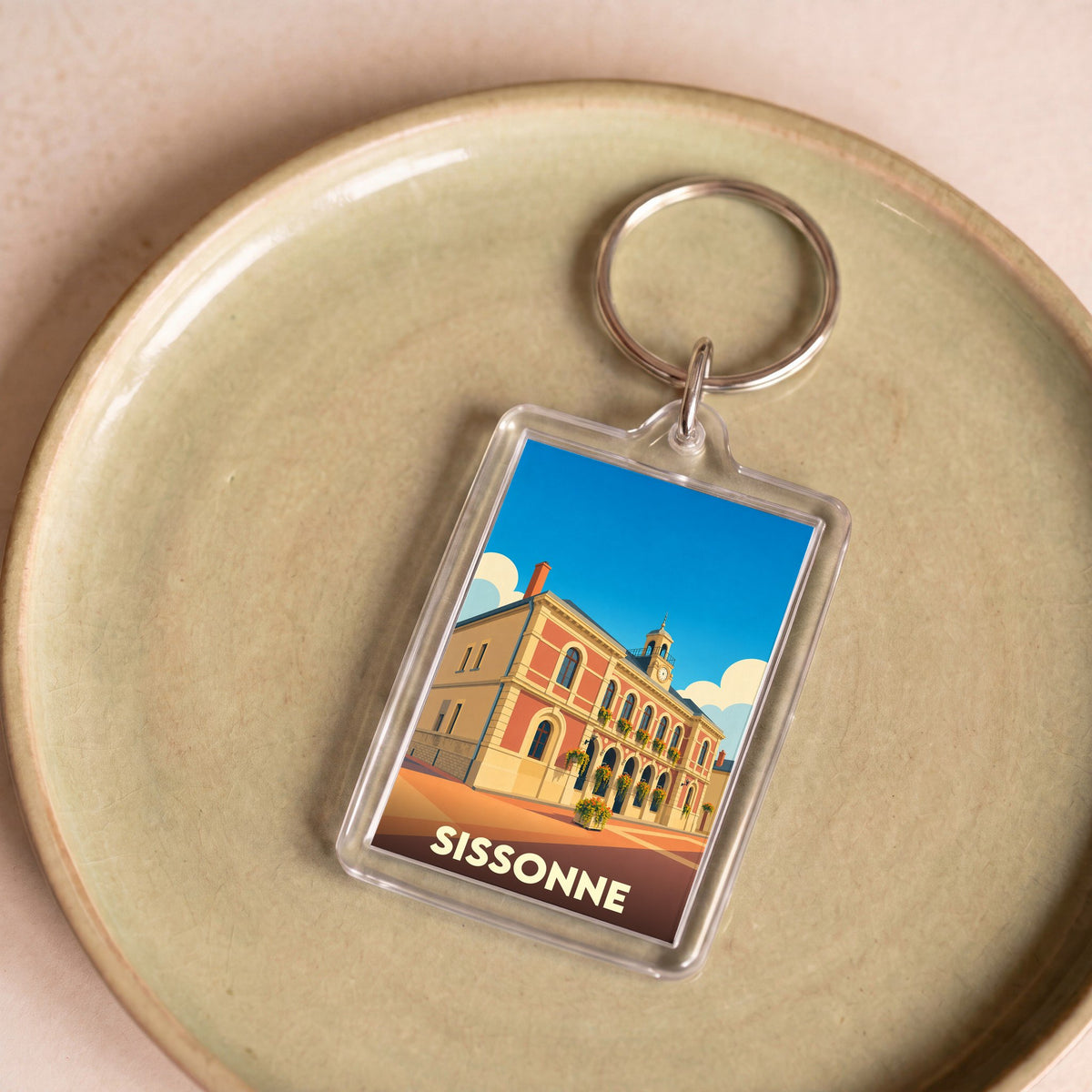 Porte-clés souvenir de la ville de Sissonne avec une illustration stylisée de son hôtel de ville.