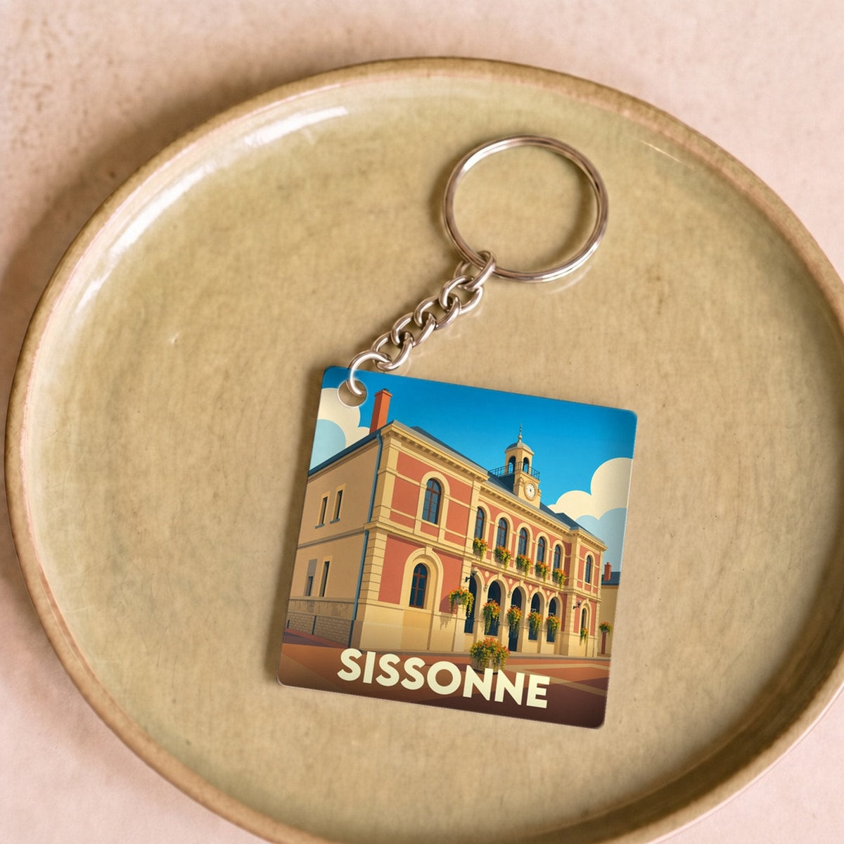 Porte-clés souvenir de la ville de Sissonne avec une illustration stylisée de son hôtel de ville.