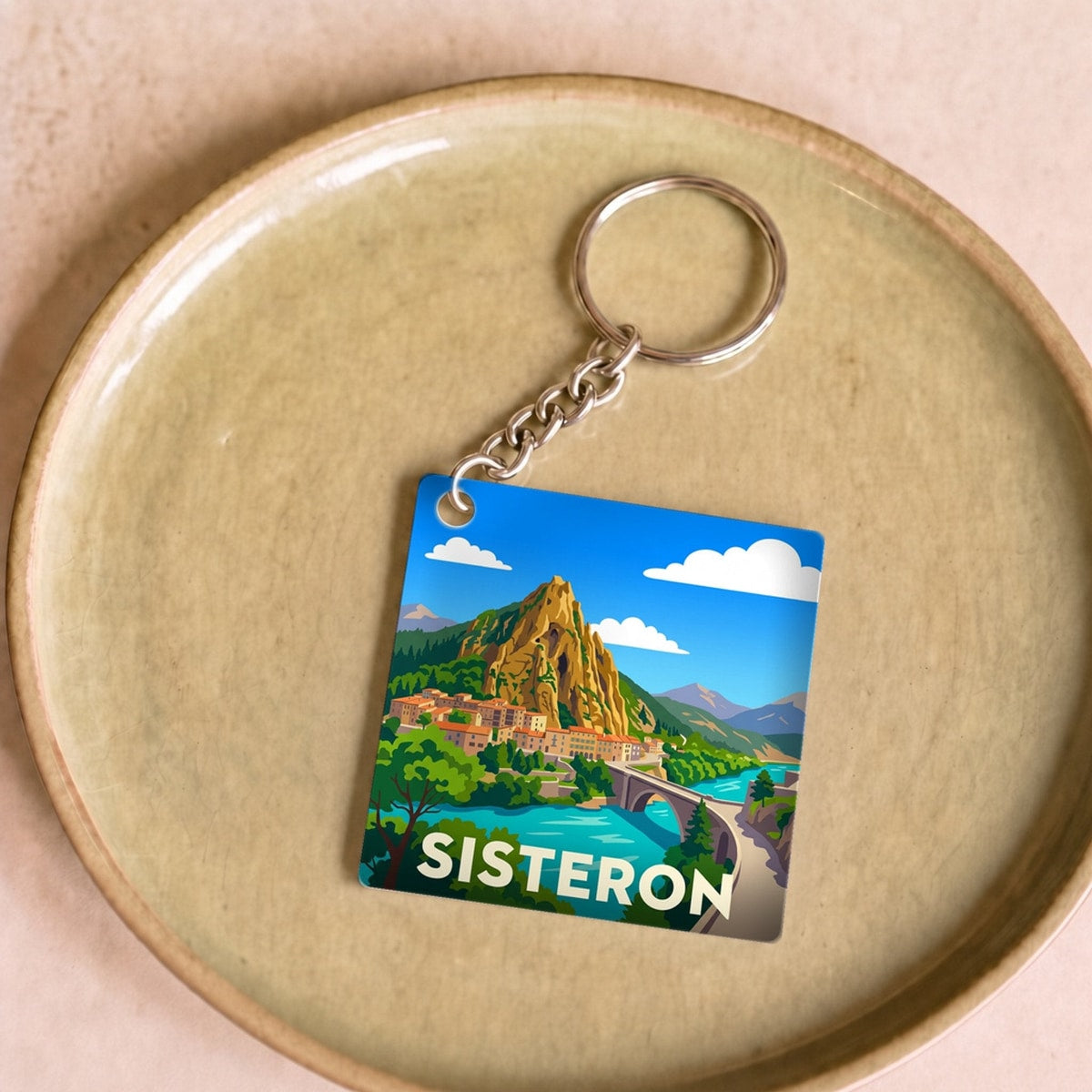 Porte-clés souvenir de la ville de Sisteron avec une illustration stylisée.