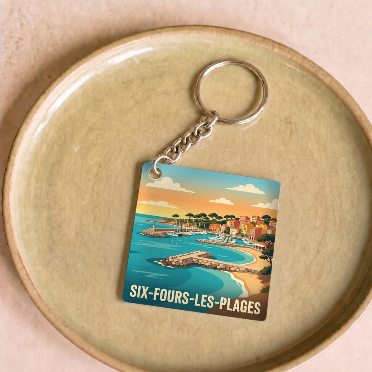 Porte-clés souvenir de la ville de Six-Fours-les-Plages avec une illustration côtière stylisée.