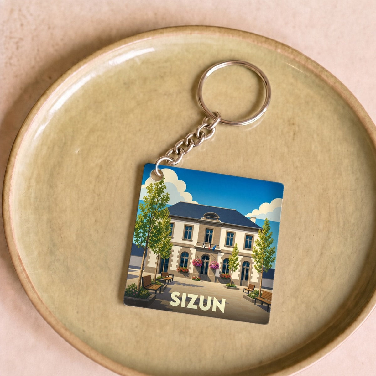 Porte-clés souvenir de la ville de Sizun avec une illustration stylisée d'un bâtiment emblématique.