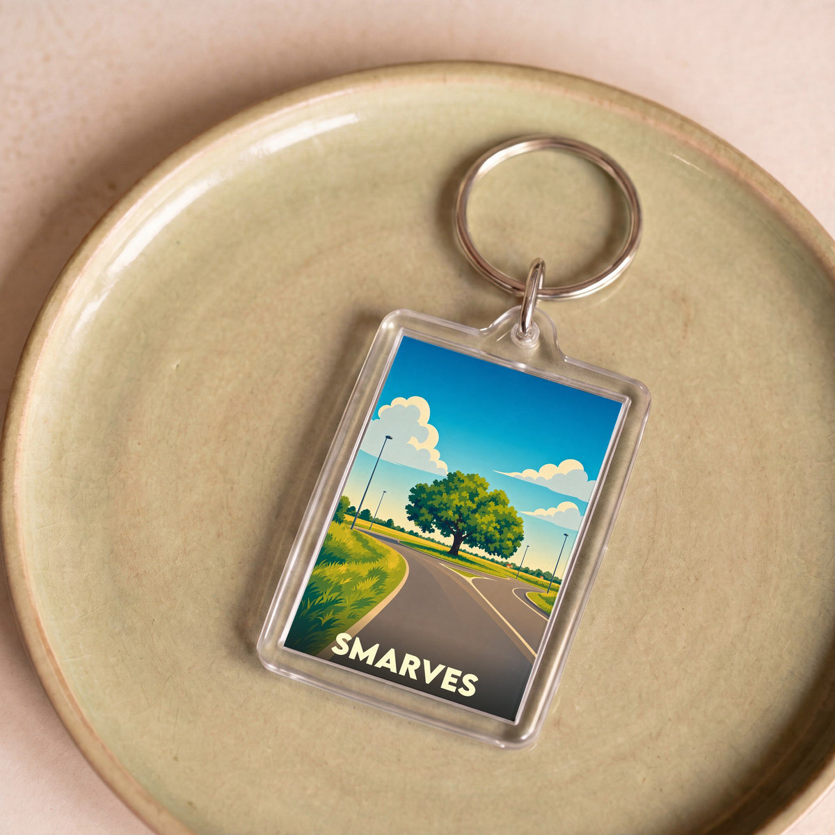 Porte-clés souvenir de la ville de Smarves avec une illustration stylisée d'un paysage de campagne.