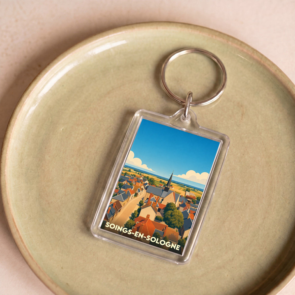 Porte-clés souvenir de la ville de Soings-en-Sologne avec une illustration stylisée.