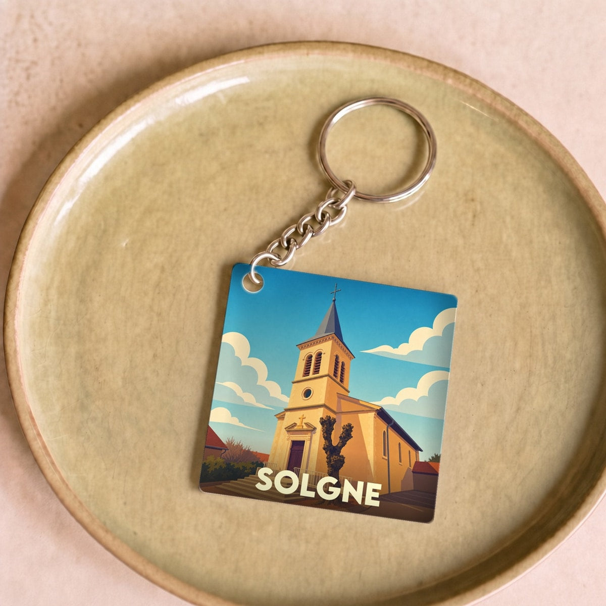 Porte-clés souvenir de la ville de Solgne avec une illustration stylisée de son église.
