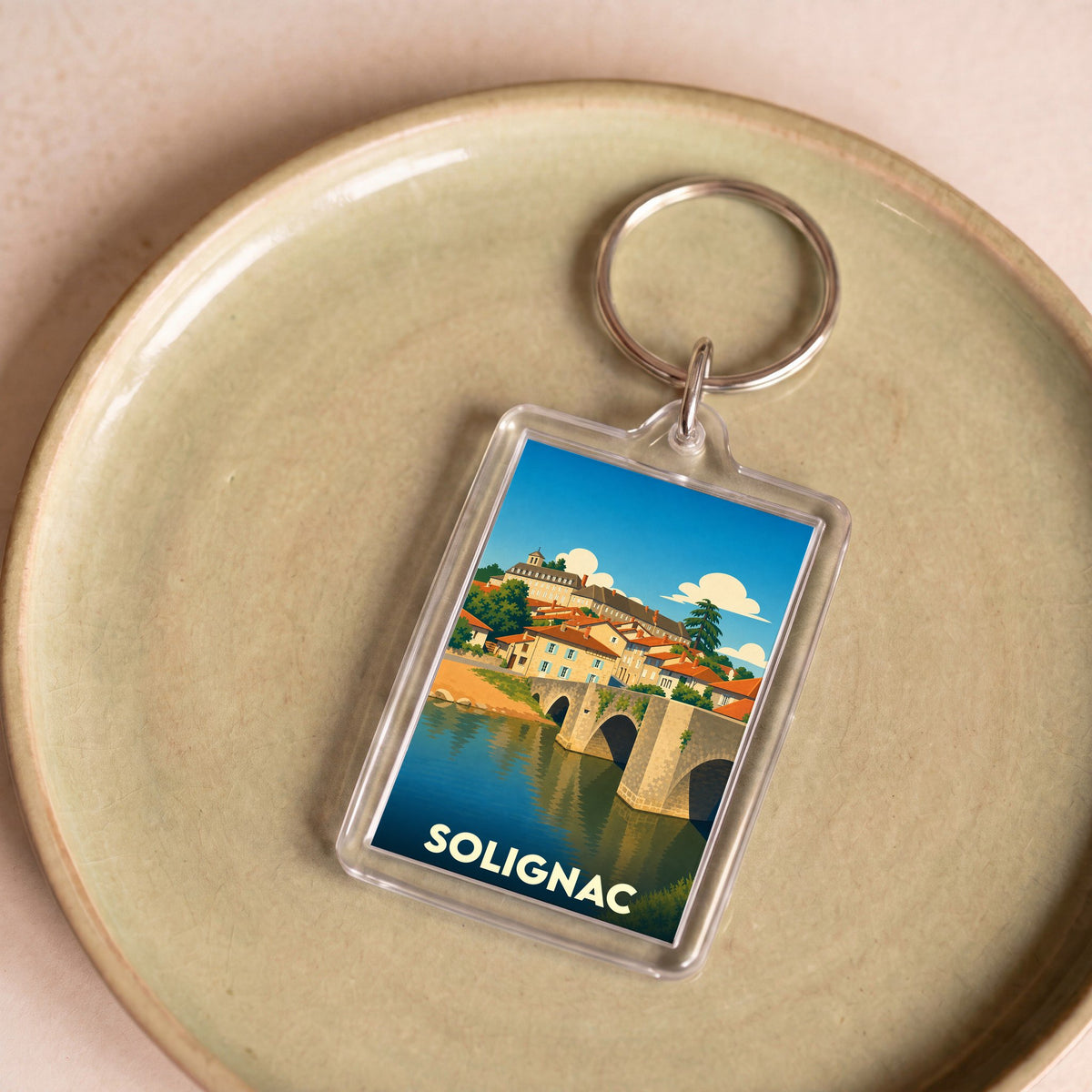 Porte-clés souvenir de la ville de Solignac avec une illustration stylisée.