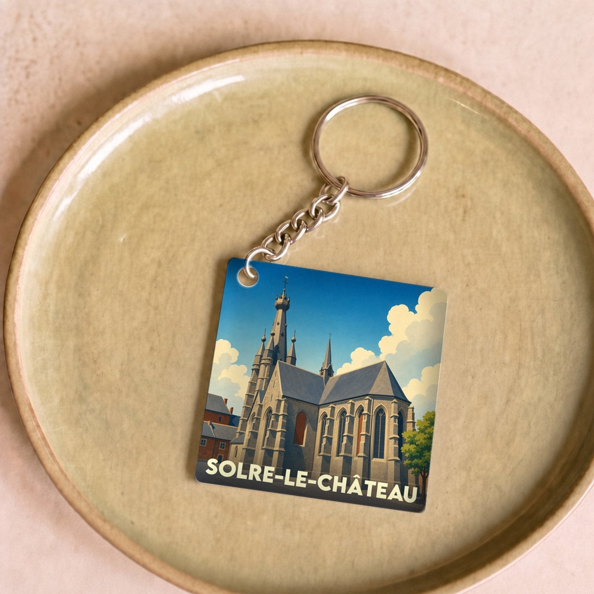 Porte-clés souvenir de la ville de Solre-le-Château avec une illustration stylisée de son église à clocher penché.