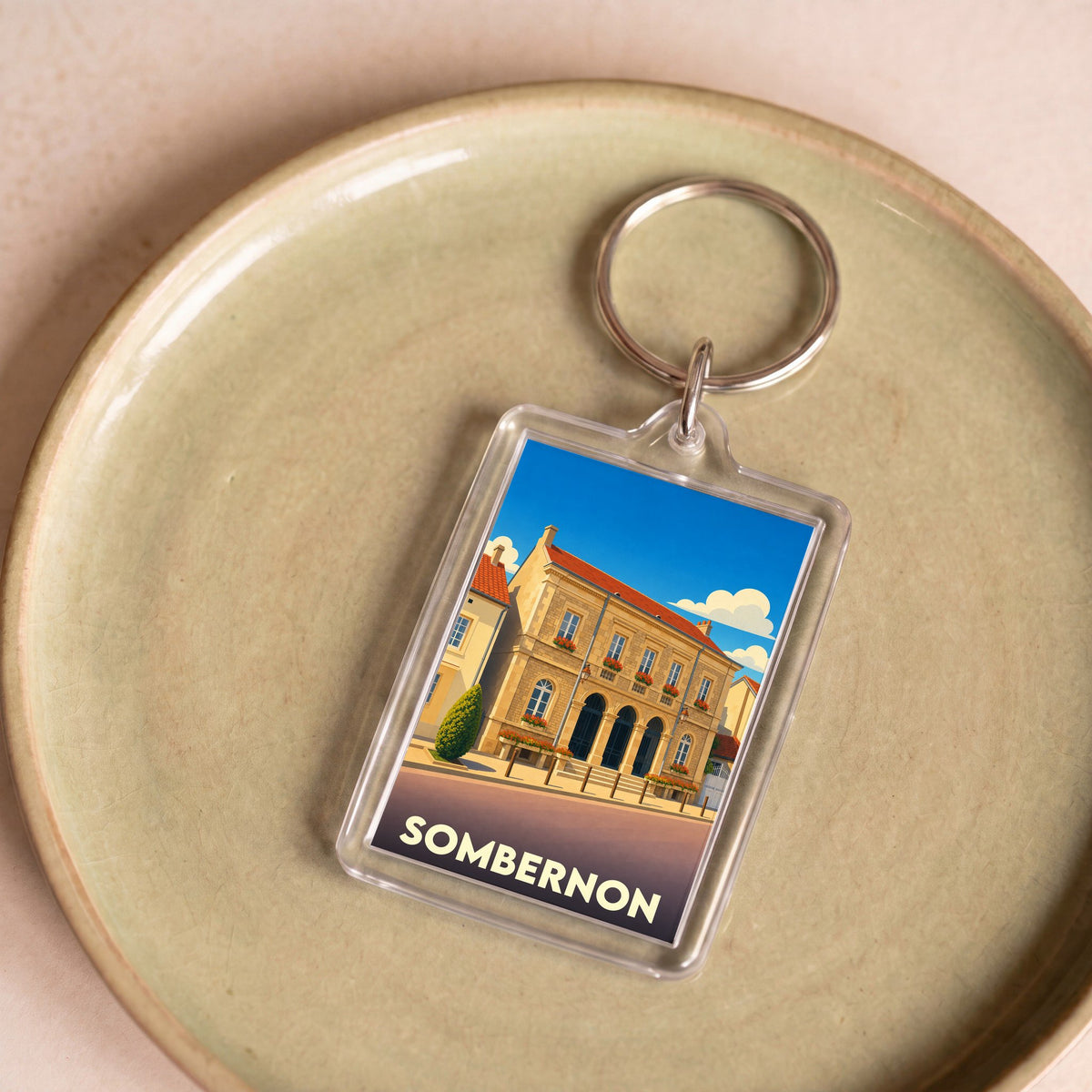 Porte-clés souvenir de la ville de Sombernon avec une illustration stylisée de son hôtel de ville.