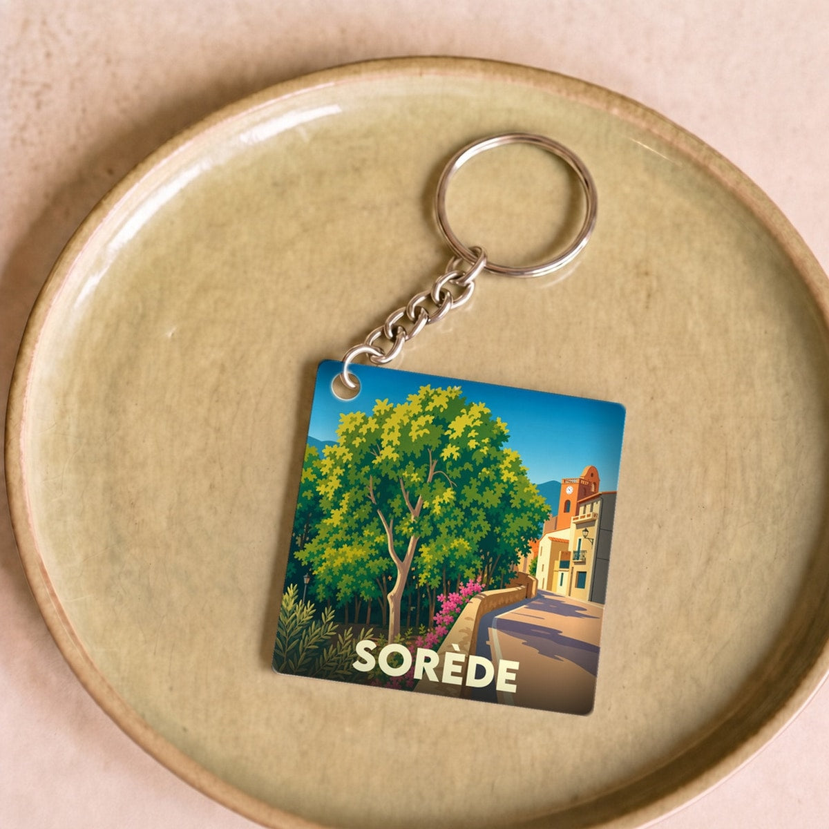 Porte-clés souvenir de la ville de Sorède avec une illustration stylisée et colorée.