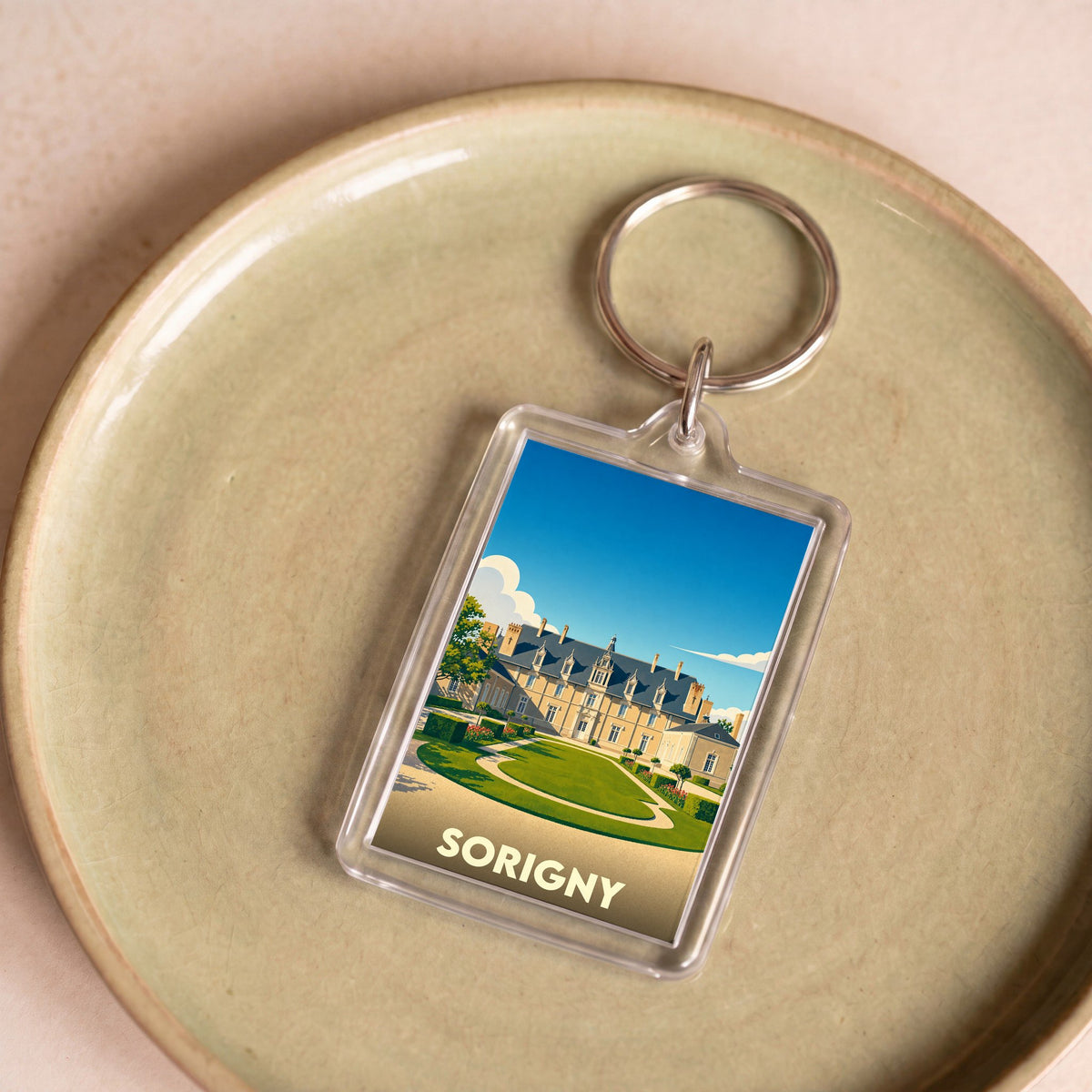 Porte-clés souvenir de la ville de Sorigny avec une illustration stylisée d'un château.
